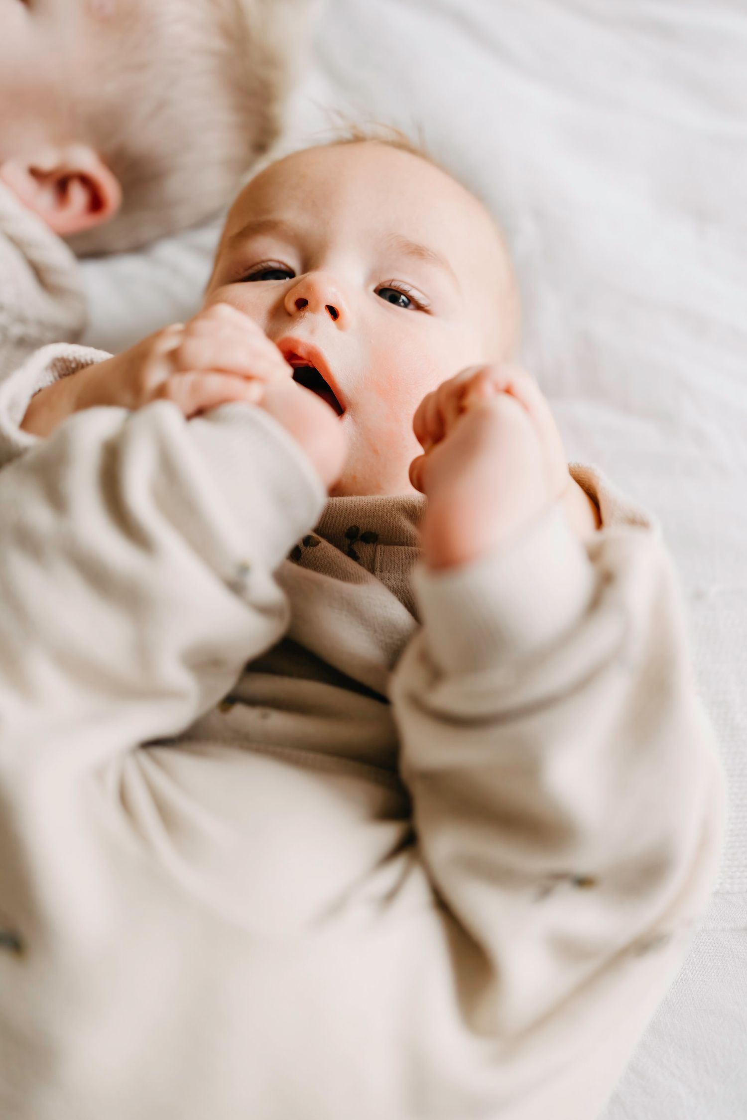 Close-up shots of a baby in a cream sweater showing various expressions.