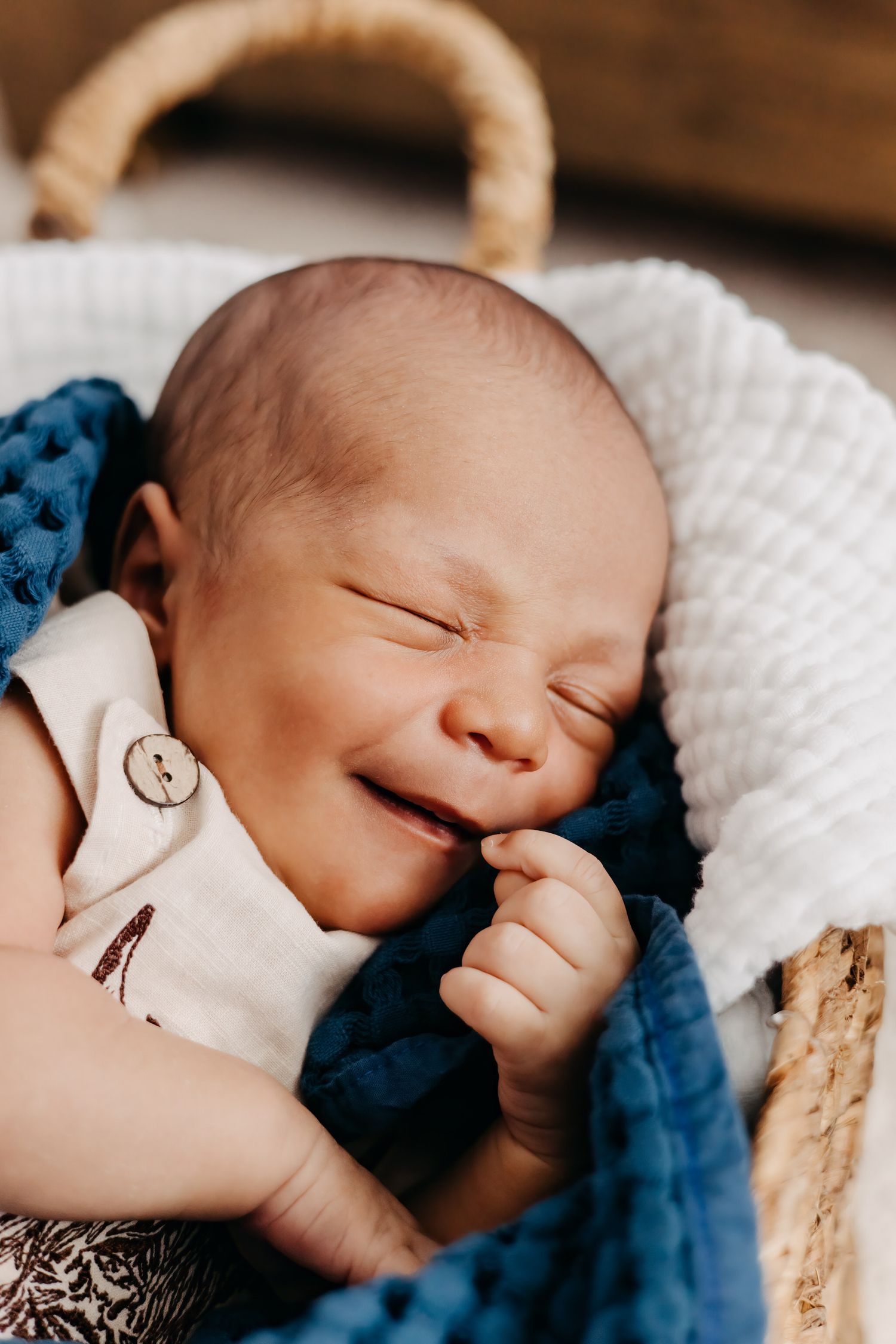 A sleeping newborn baby smiling in sleep.