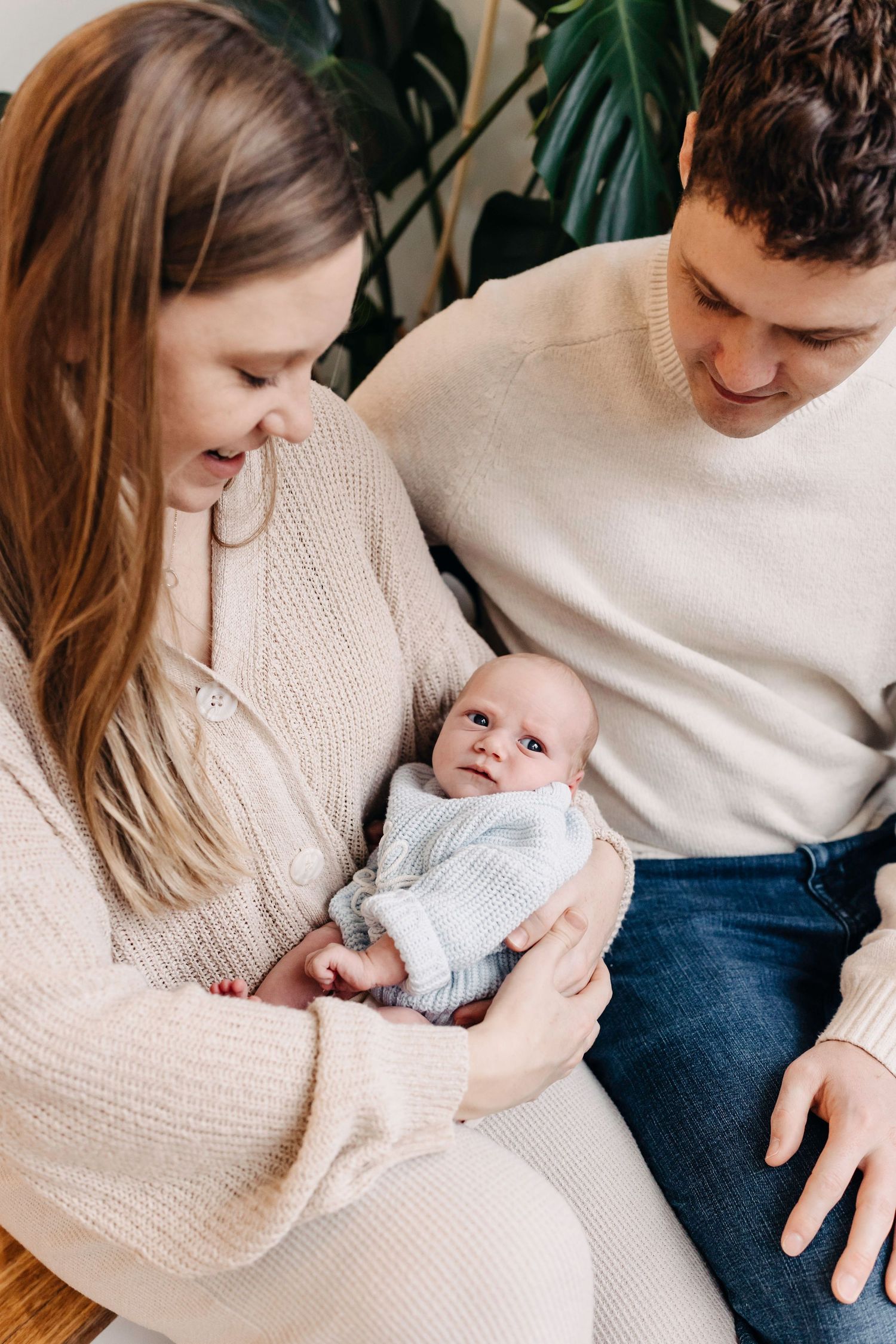 A tender family moment captured in a series of intimate photos showing parents bonding with their newborn baby.