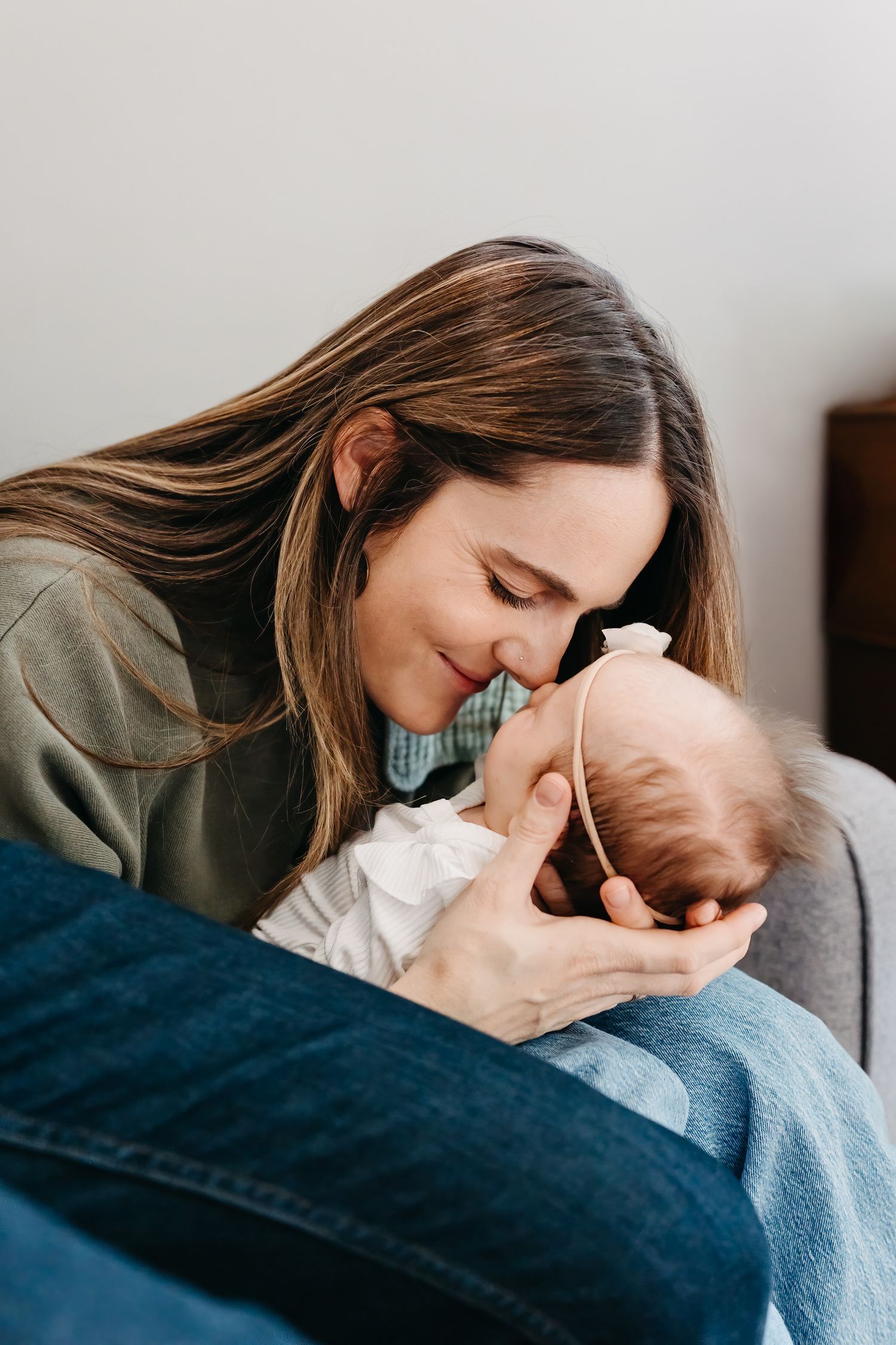 A tender moment shows a parent gently nuzzling their sleeping baby.