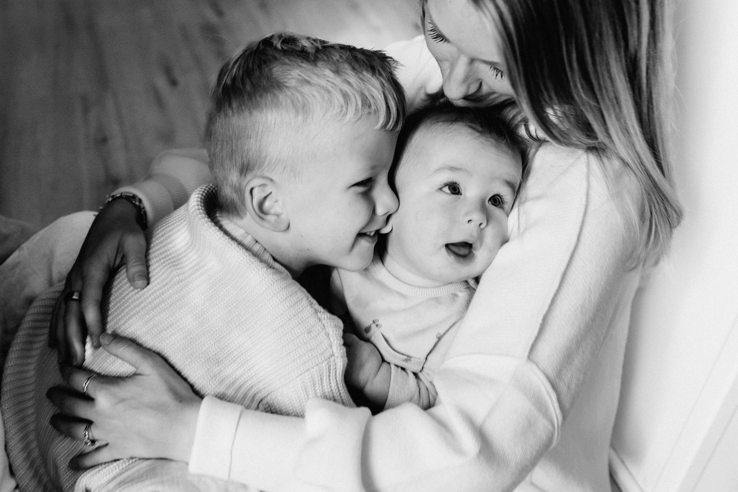 A tender black and white collage of intimate newborn moments with parents showing gentle touches and cuddles.
