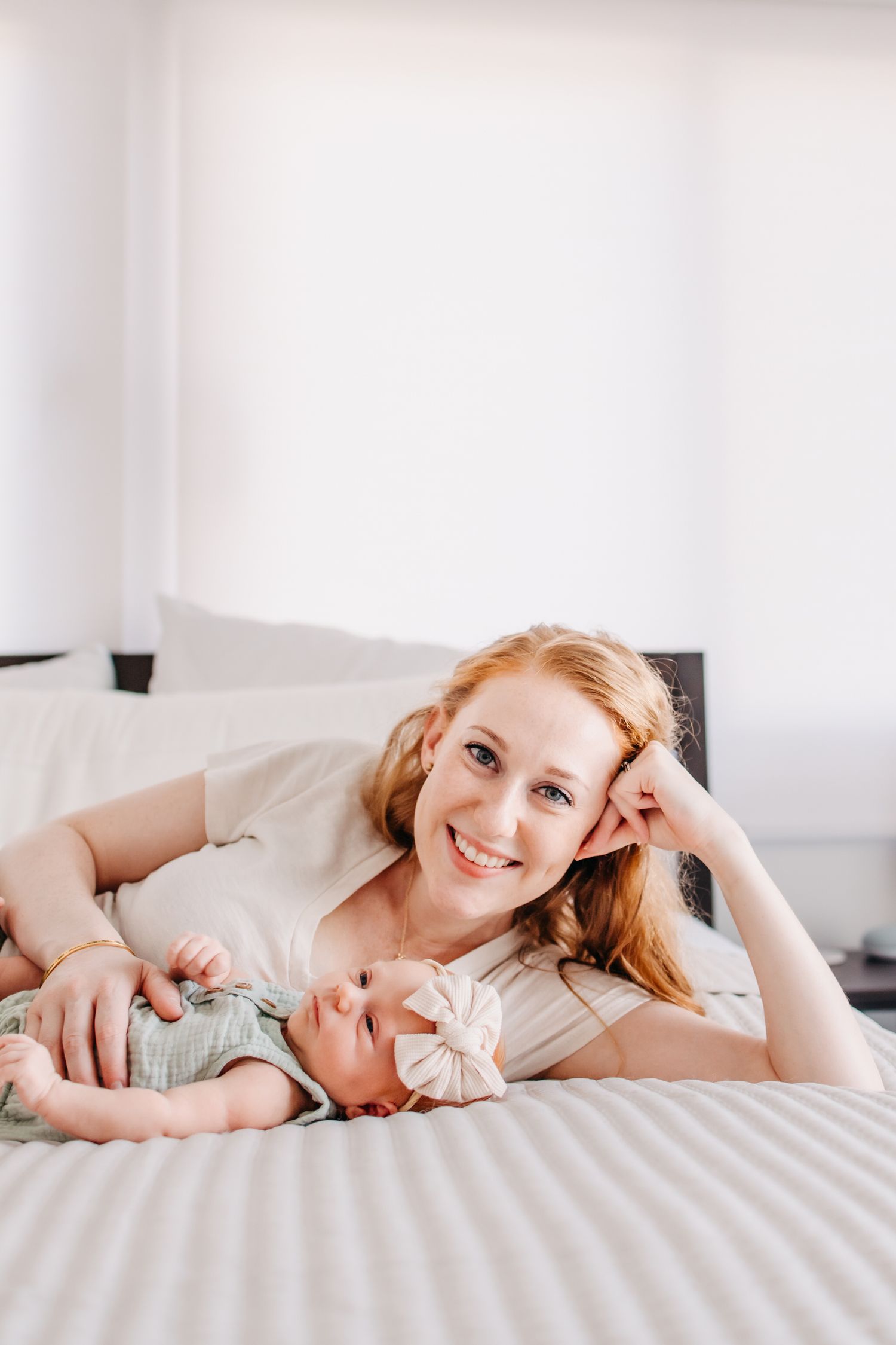Intimate lifestyle photos of tender moments on white bedding in natural light.