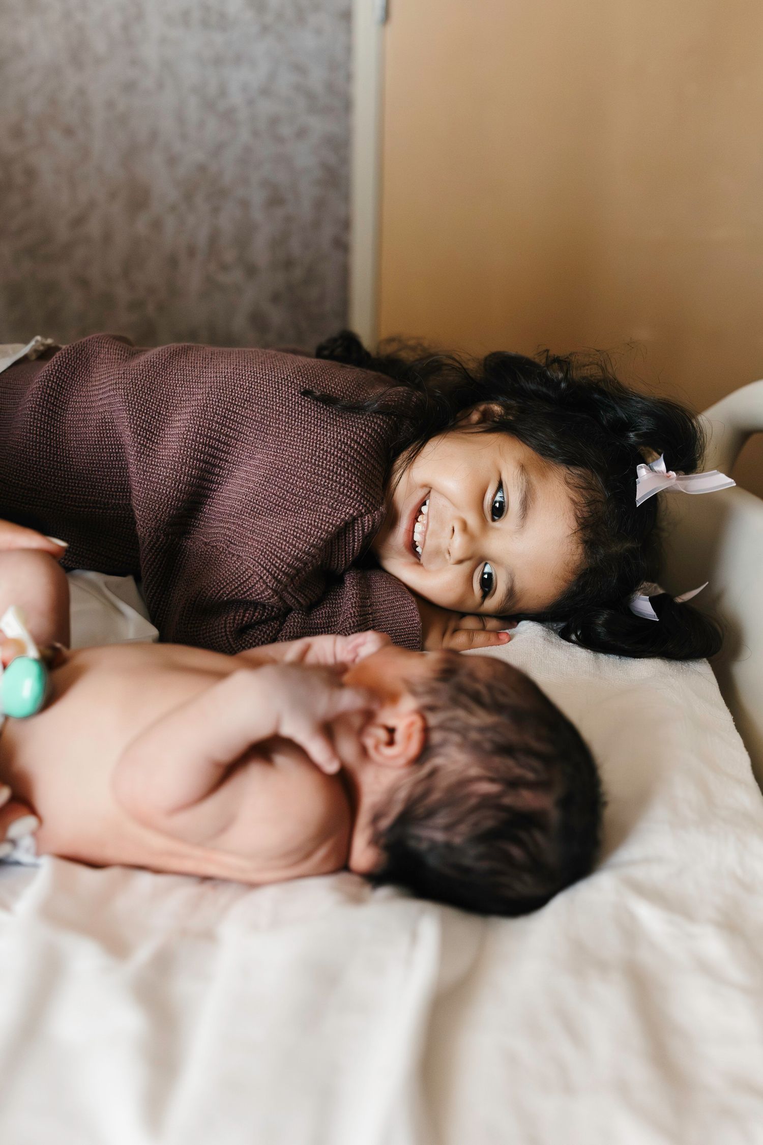 New big sister smiling at infant brother
