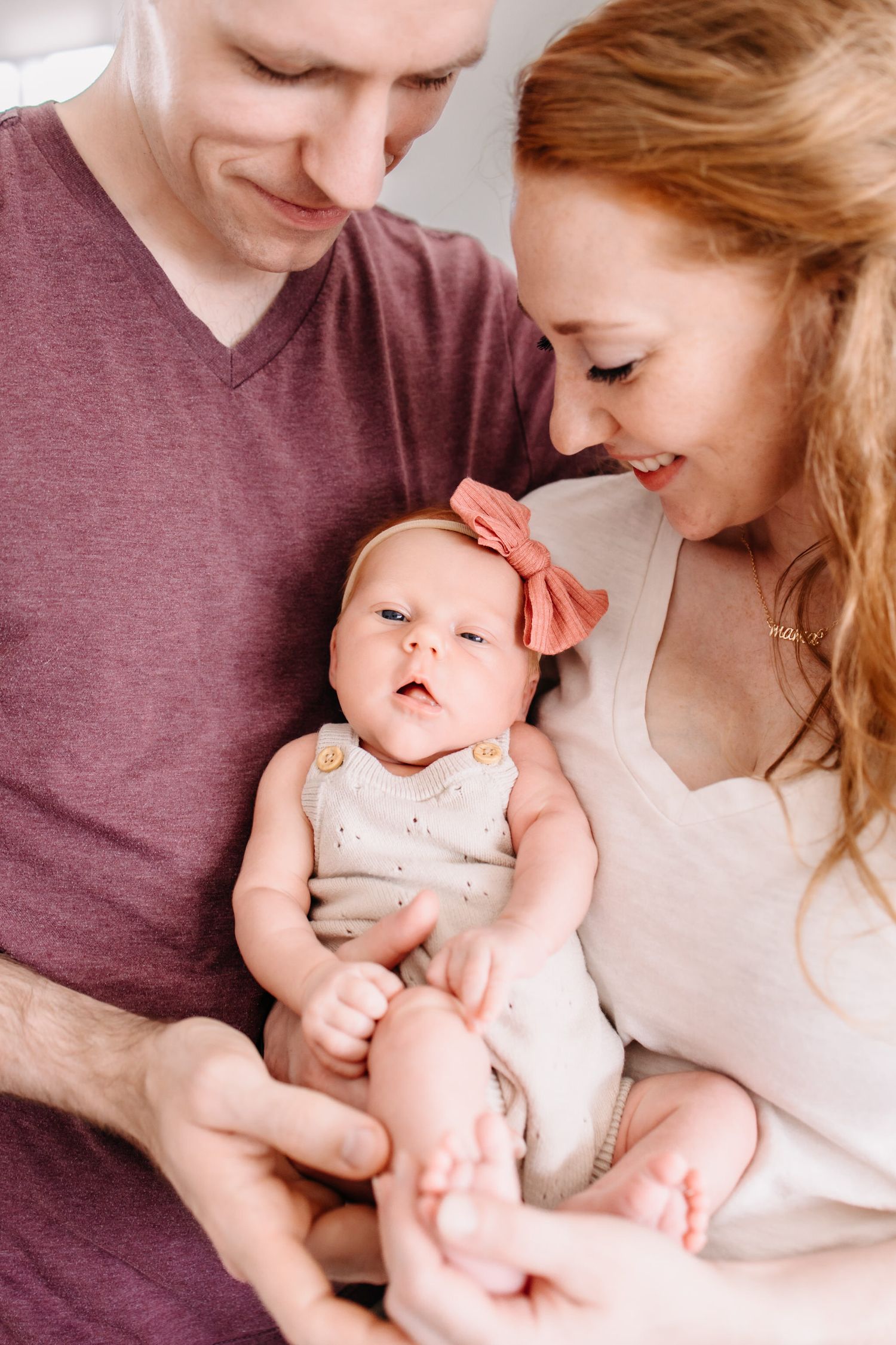 A series of intimate family portraits showing tender moments between parents and their smiling baby in soft lighting.