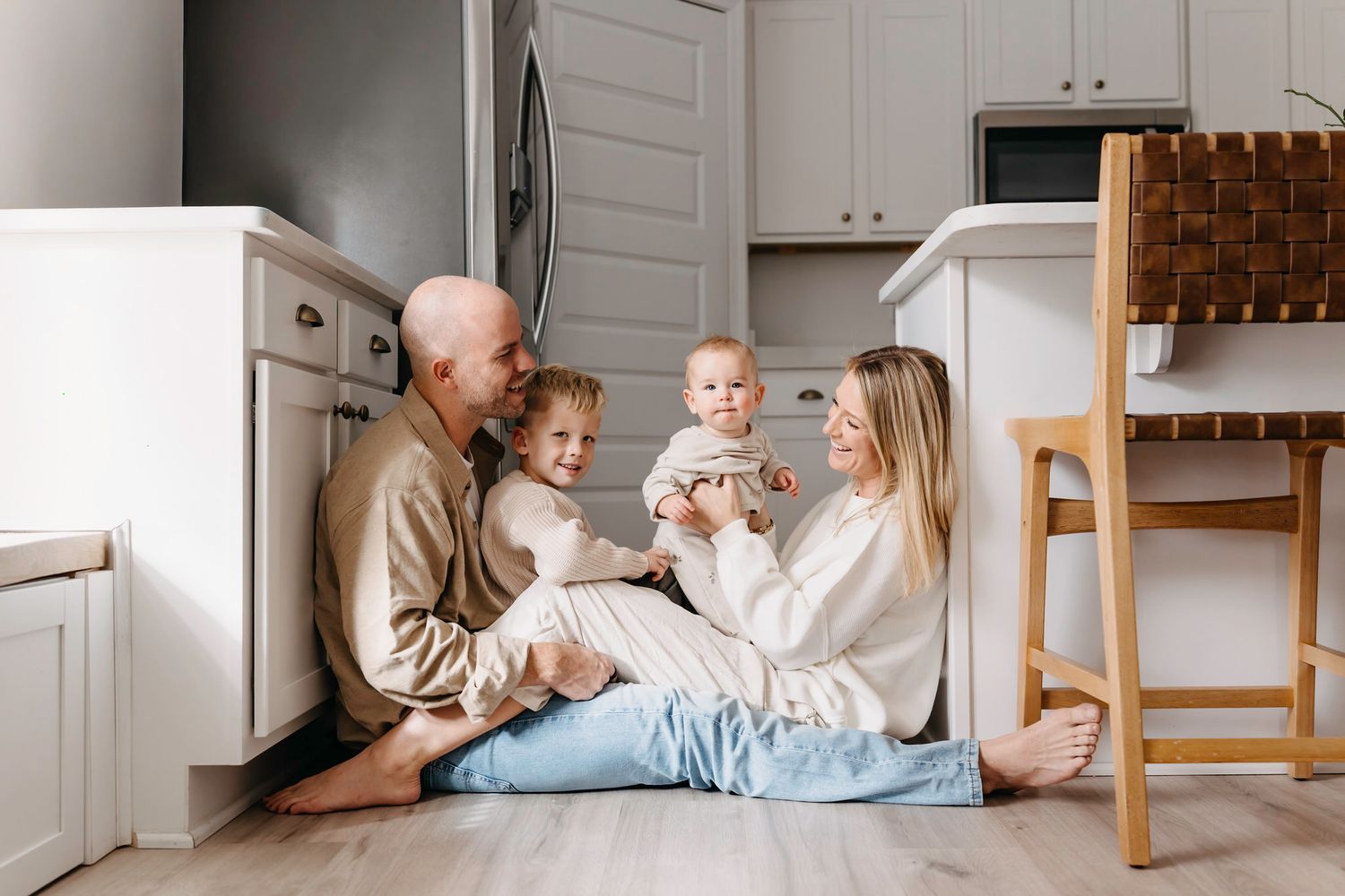 Casual family moments in a bright kitchen with white cabinets and wooden accents.