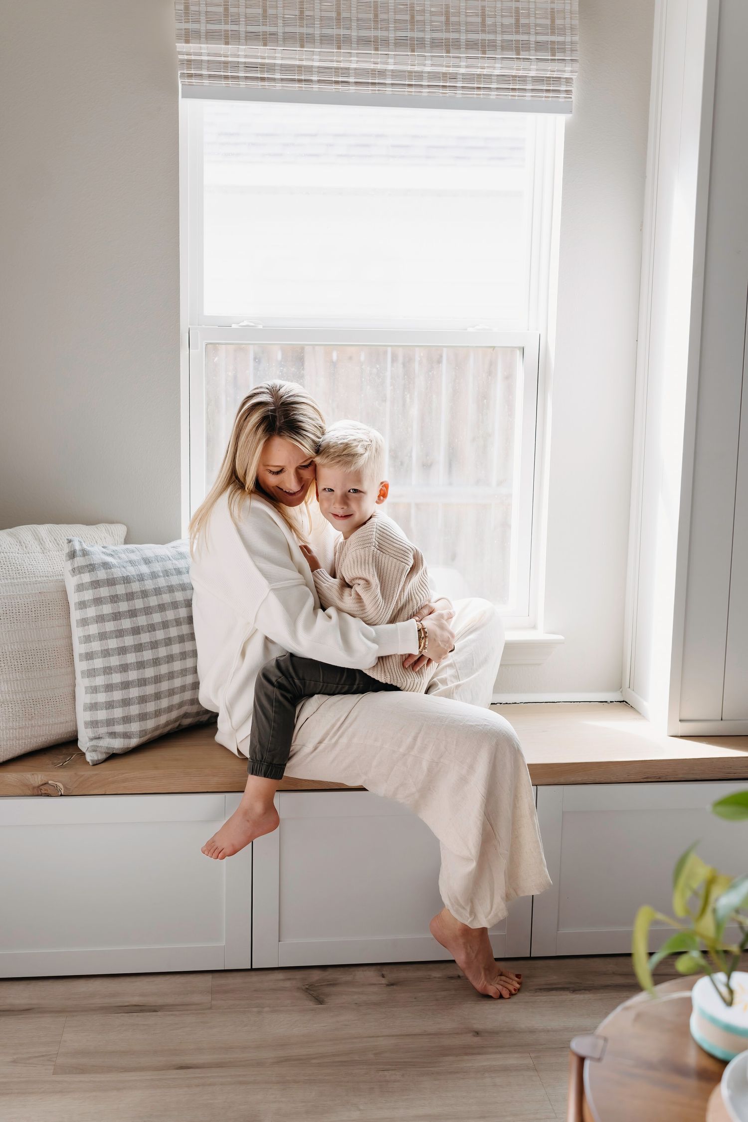 Intimate family moments captured by a window seat in soft natural light.