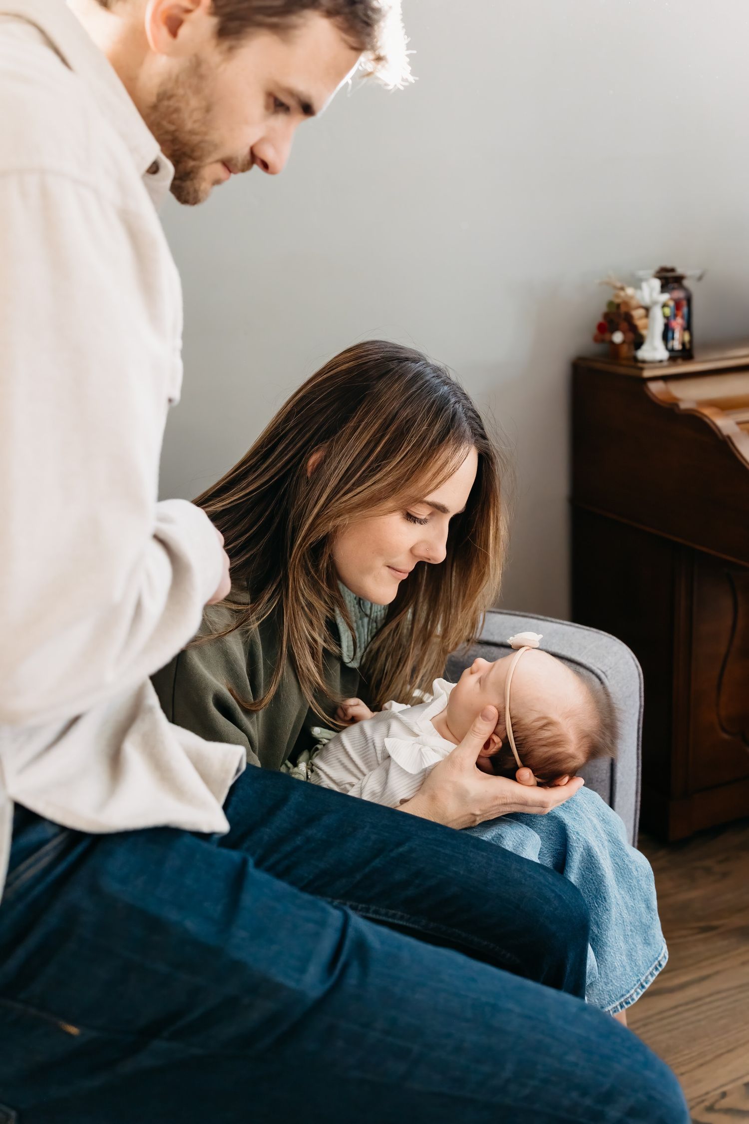 Parents lovingly tend to their newborn baby in a series of tender moments captured in soft natural light.