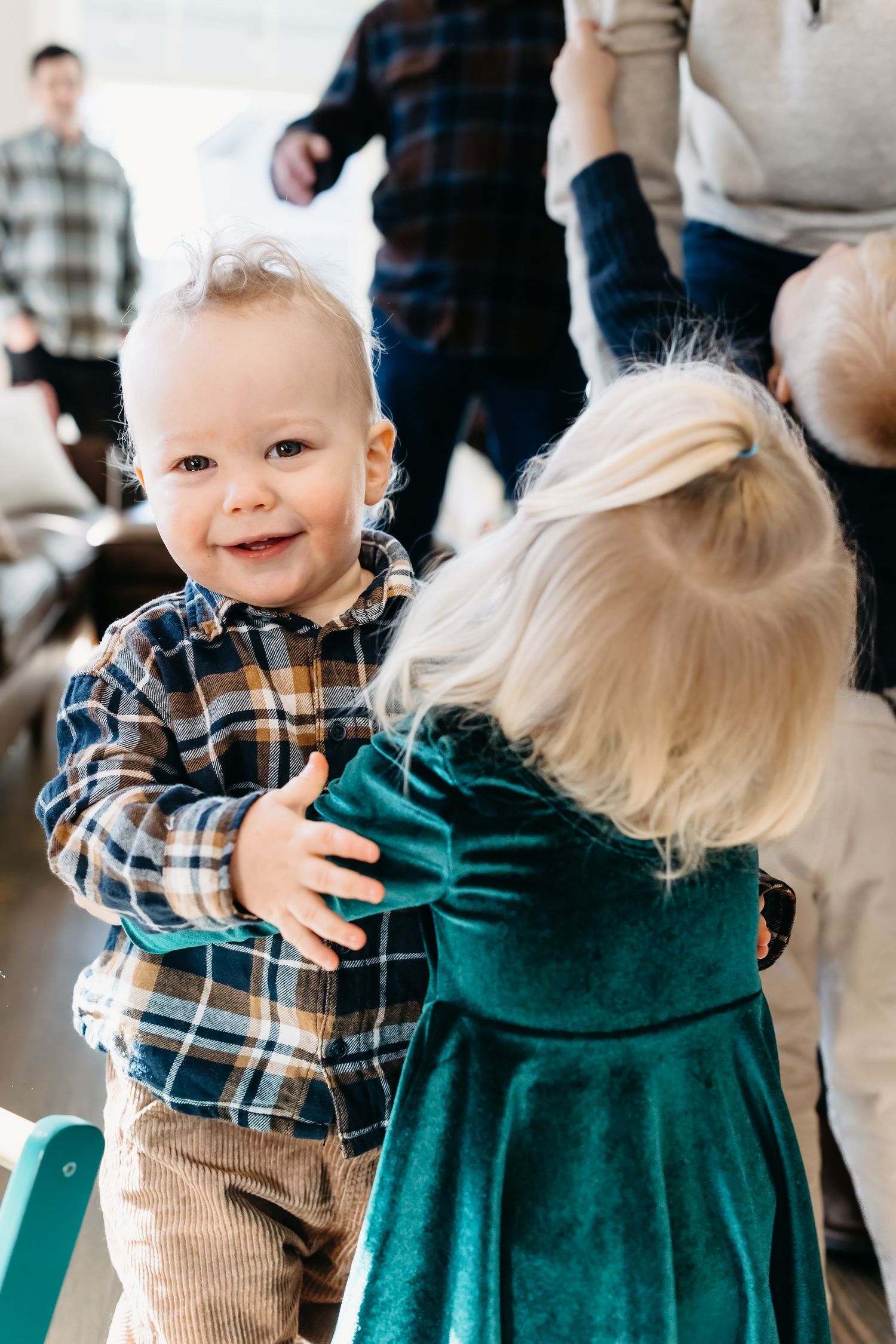 A heartwarming sequence of photos showing a toddler in plaid and corduroy giving a warm embrace at a gathering.