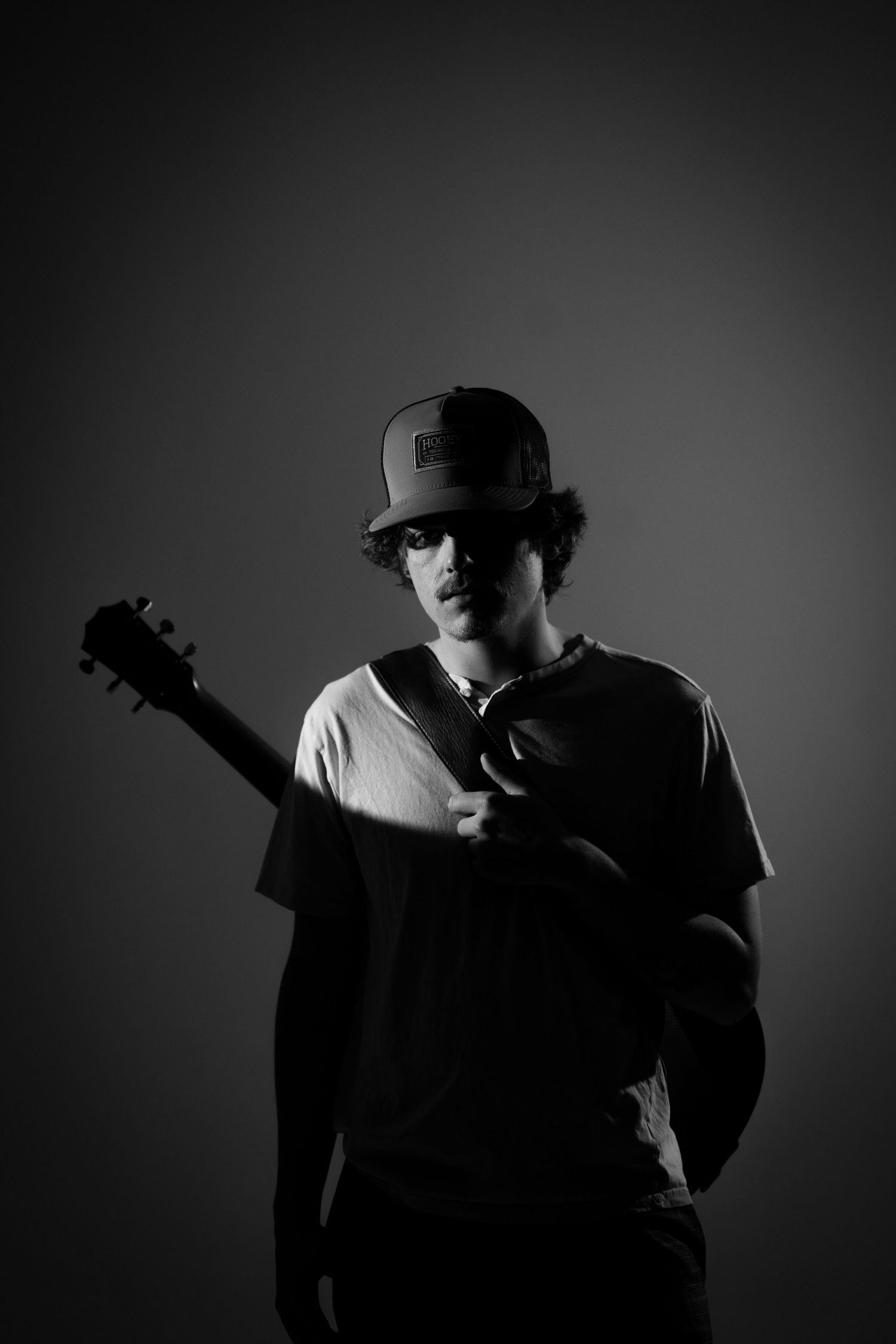 Silhouetted guitarist creates dramatic poses against grey background.