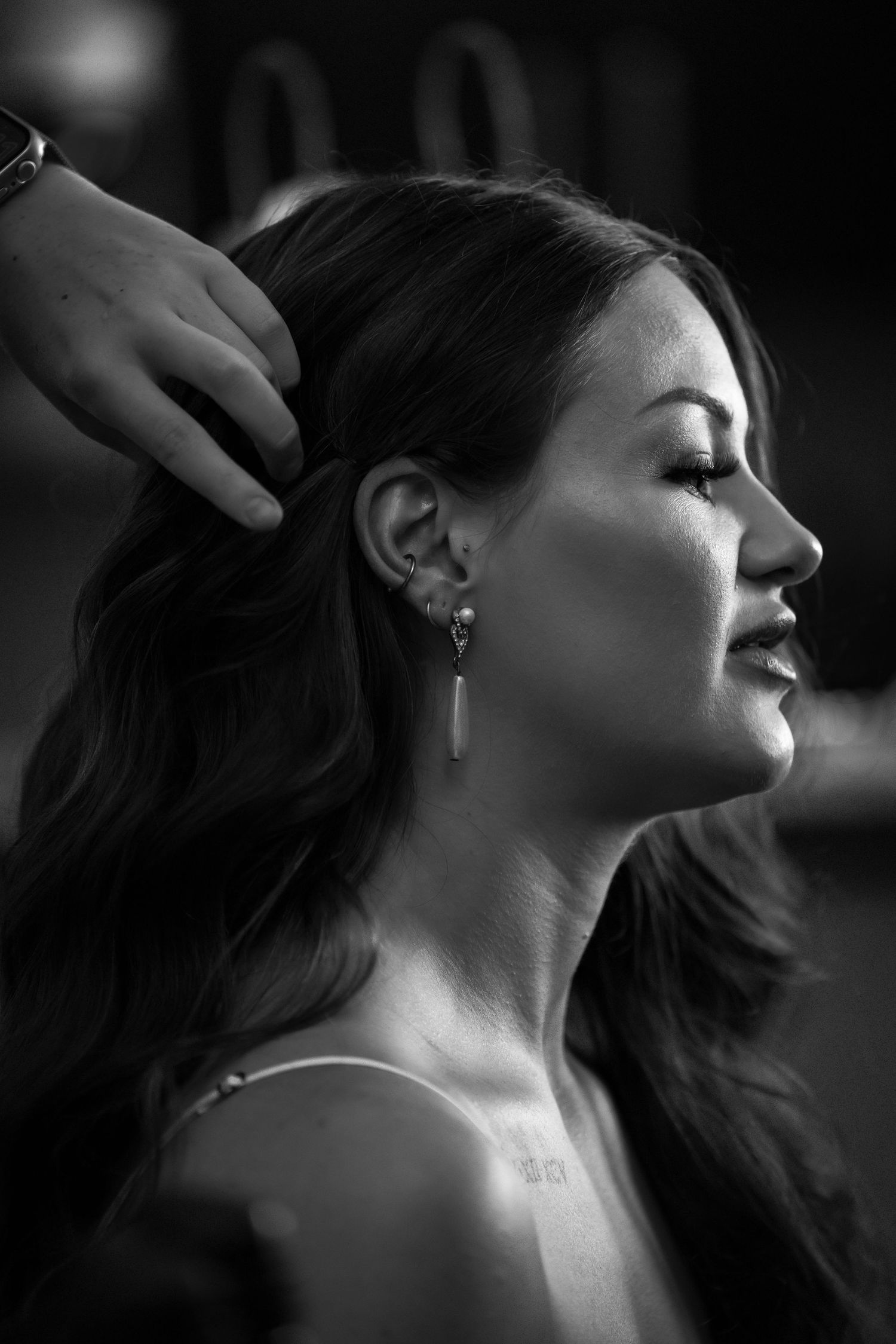 Dramatic black and white profile shot showing wedding day hair and makeup styling.