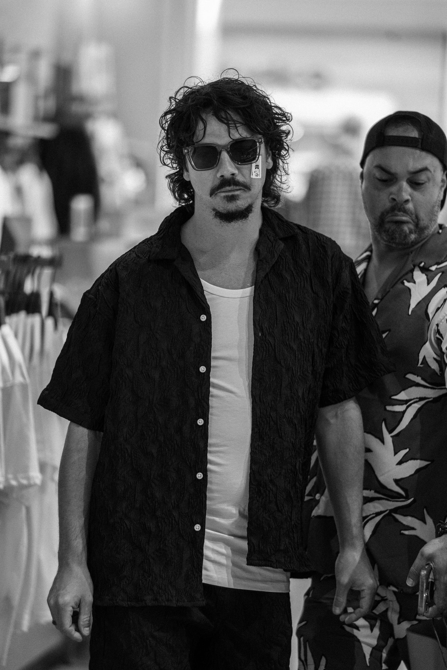 Group walking through retail space wearing casual black and white attire.
