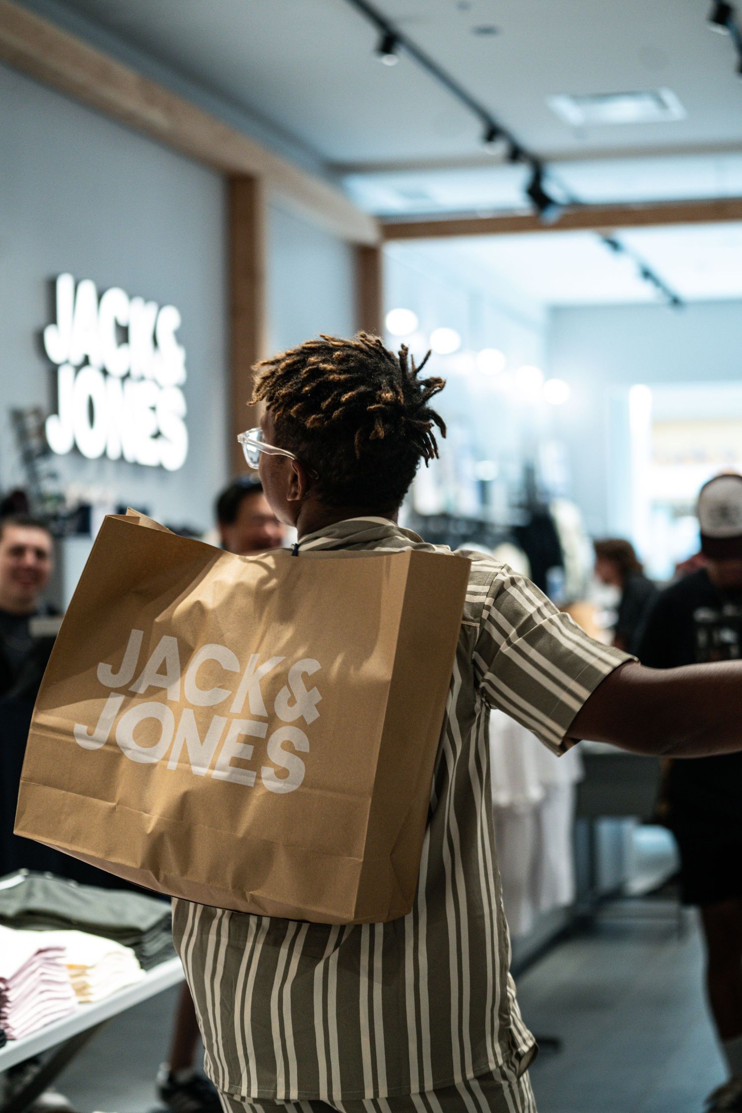 Shopping bags with branding displayed in retail store environment.