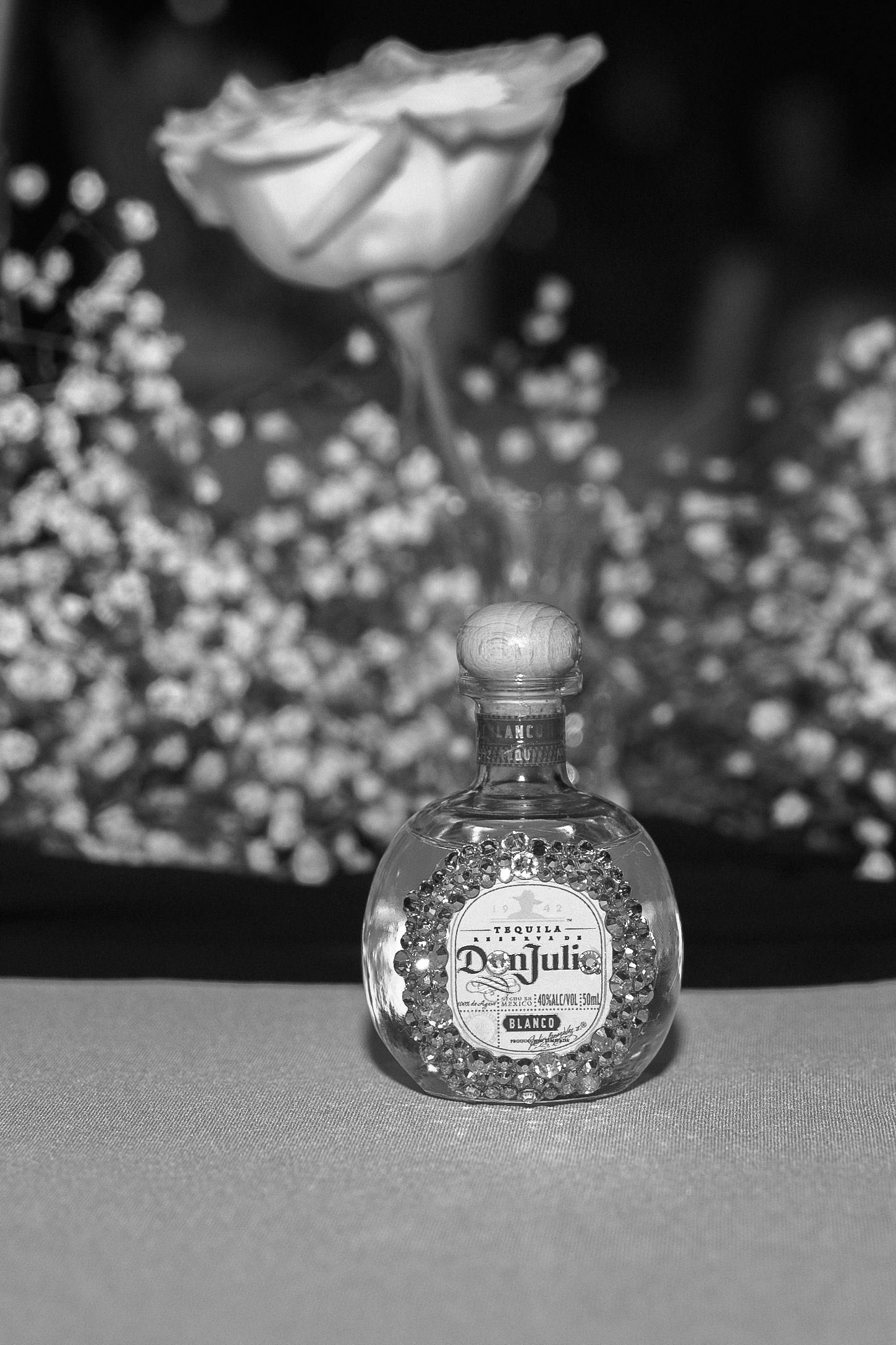 Decorative glass perfume bottles arranged in a sequence against a dark background with bokeh effects.