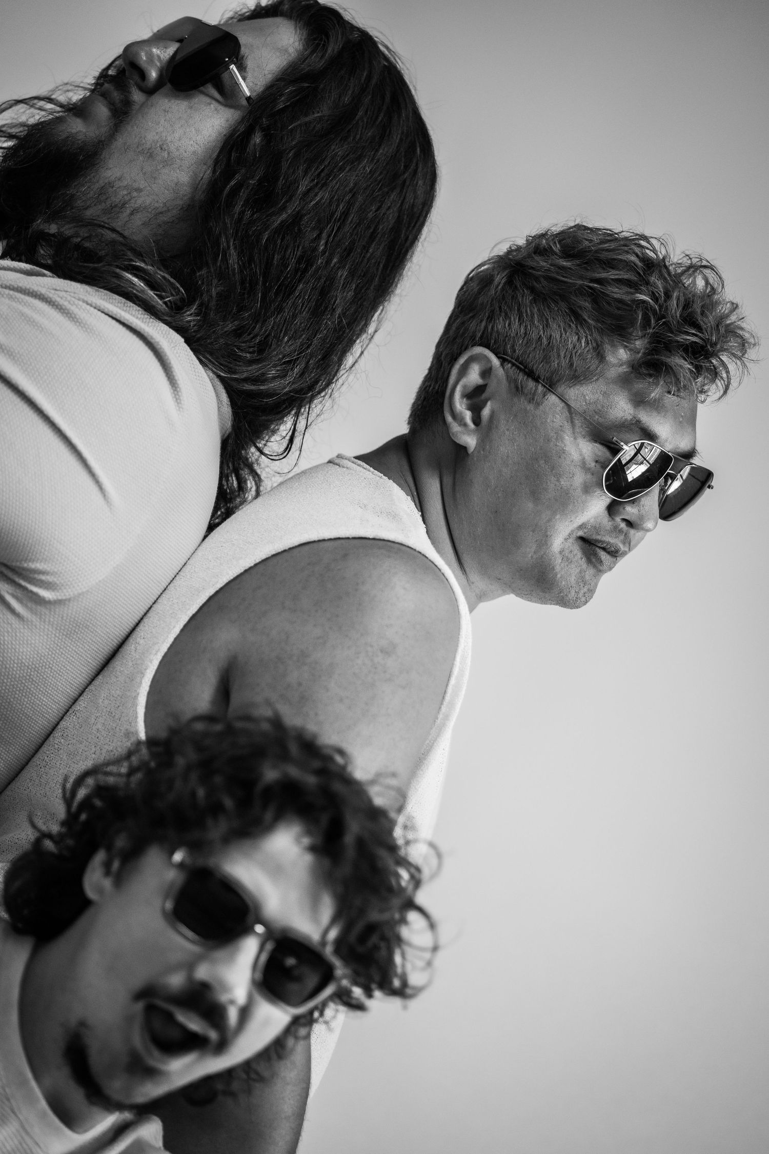 Artistic black and white portrait series showing dynamic angles and sunglasses.