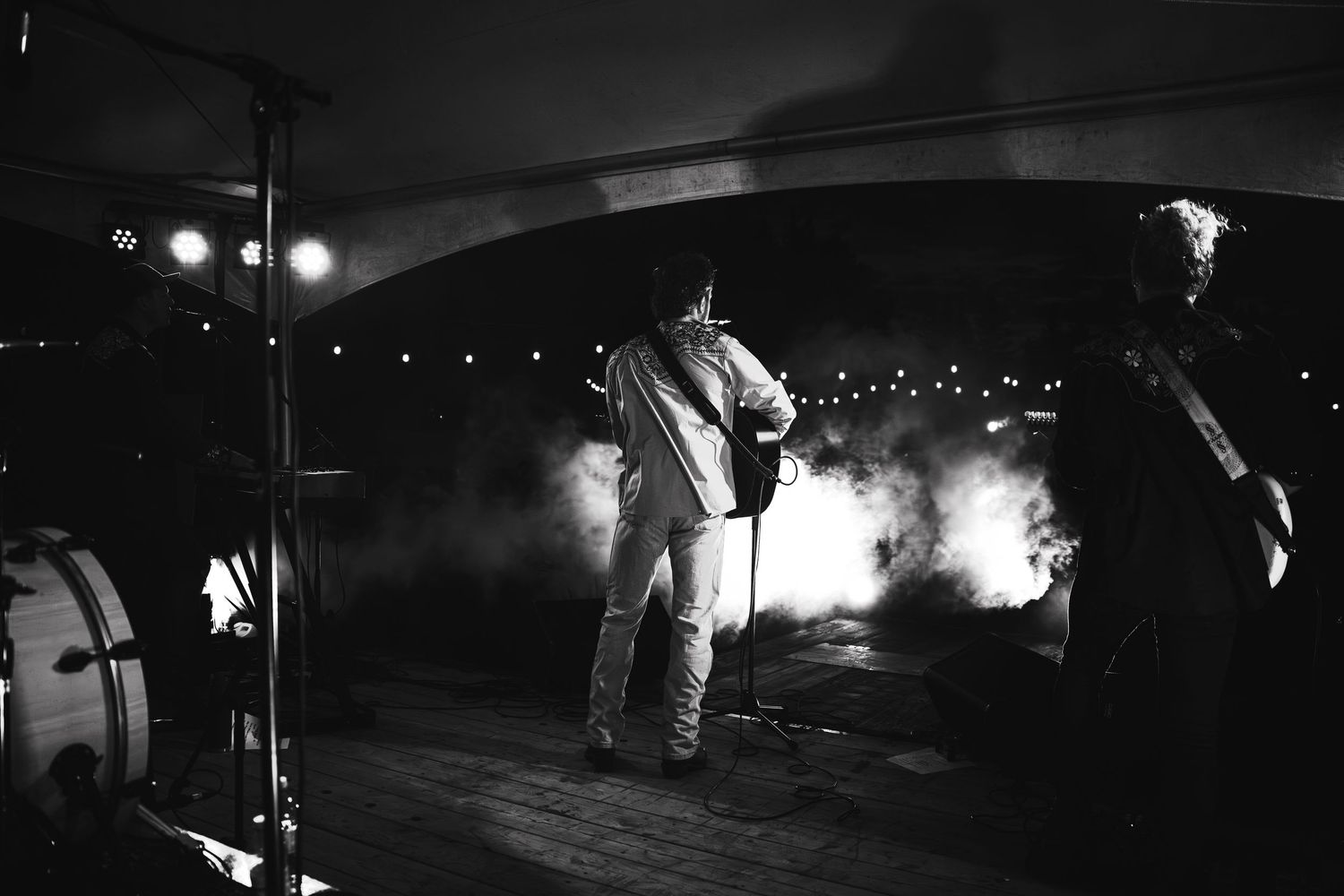 Dark nighttime performance scene with atmospheric lighting and smoke effects.