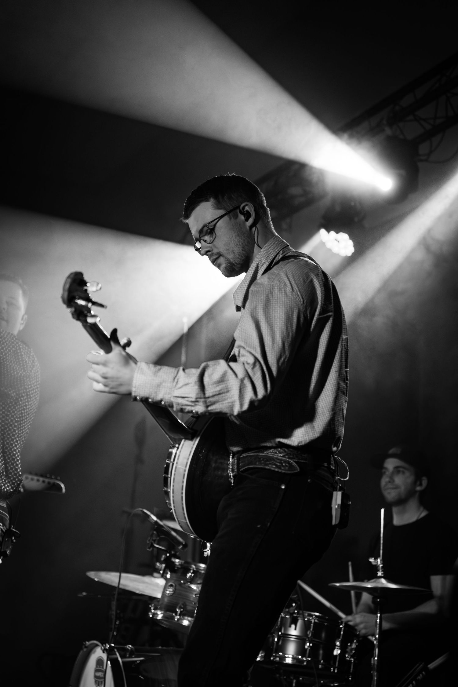 Black and white photo of musicians performing on stage with dramatic lighting.