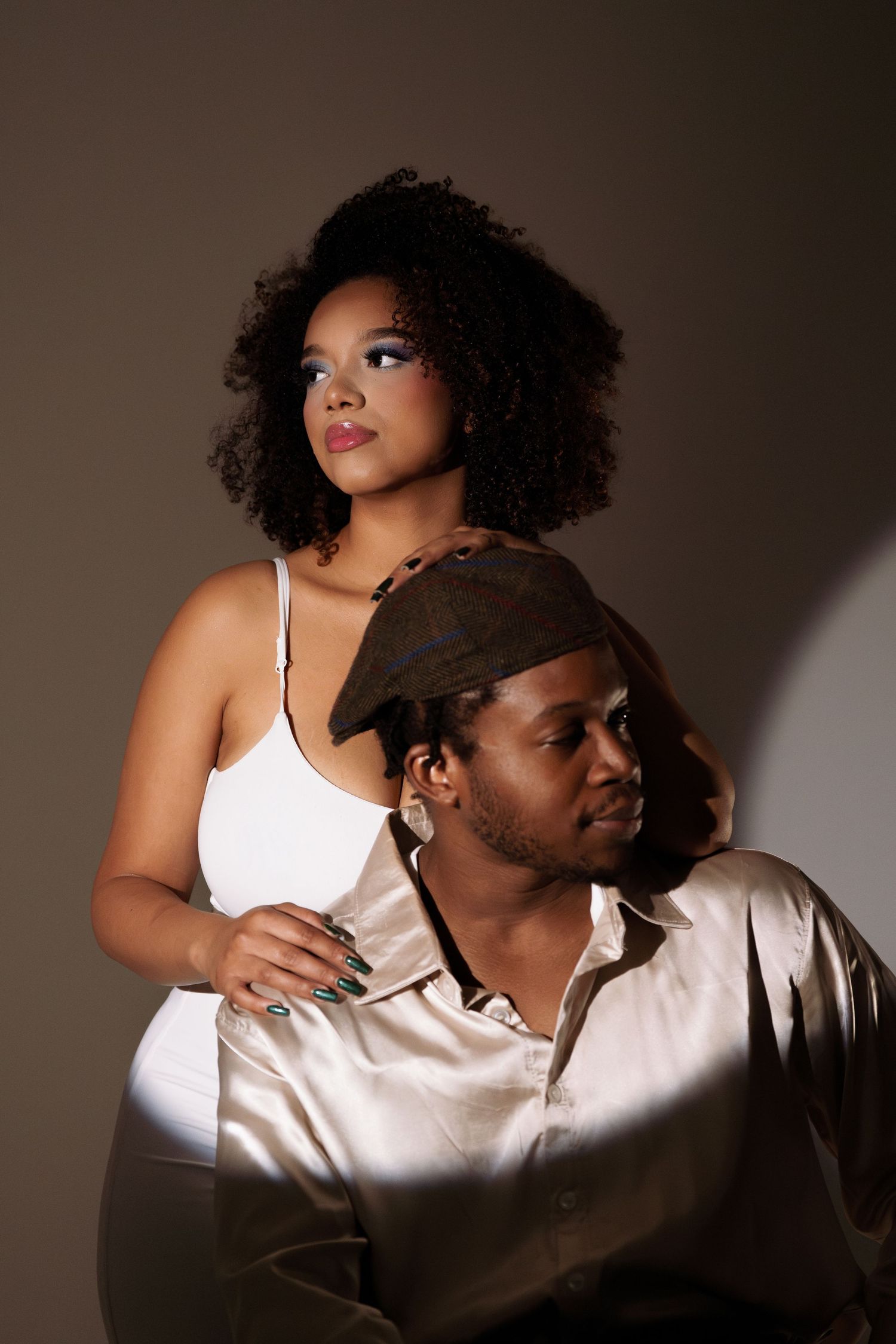 Artistic studio shots featuring two people in white clothing with dramatic shadows.