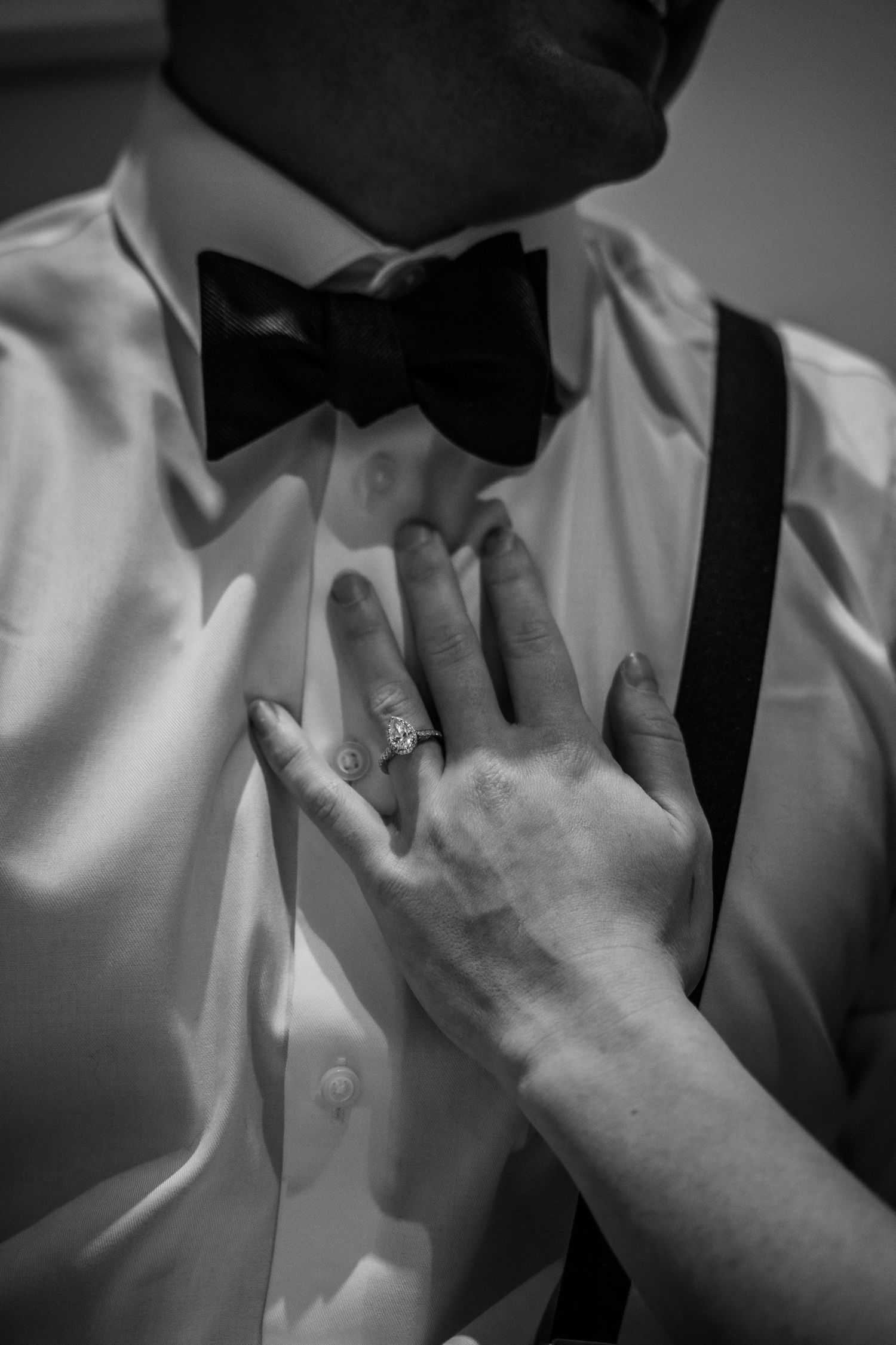 Close-up of formal attire details showing bow tie and white shirt in black and white.
