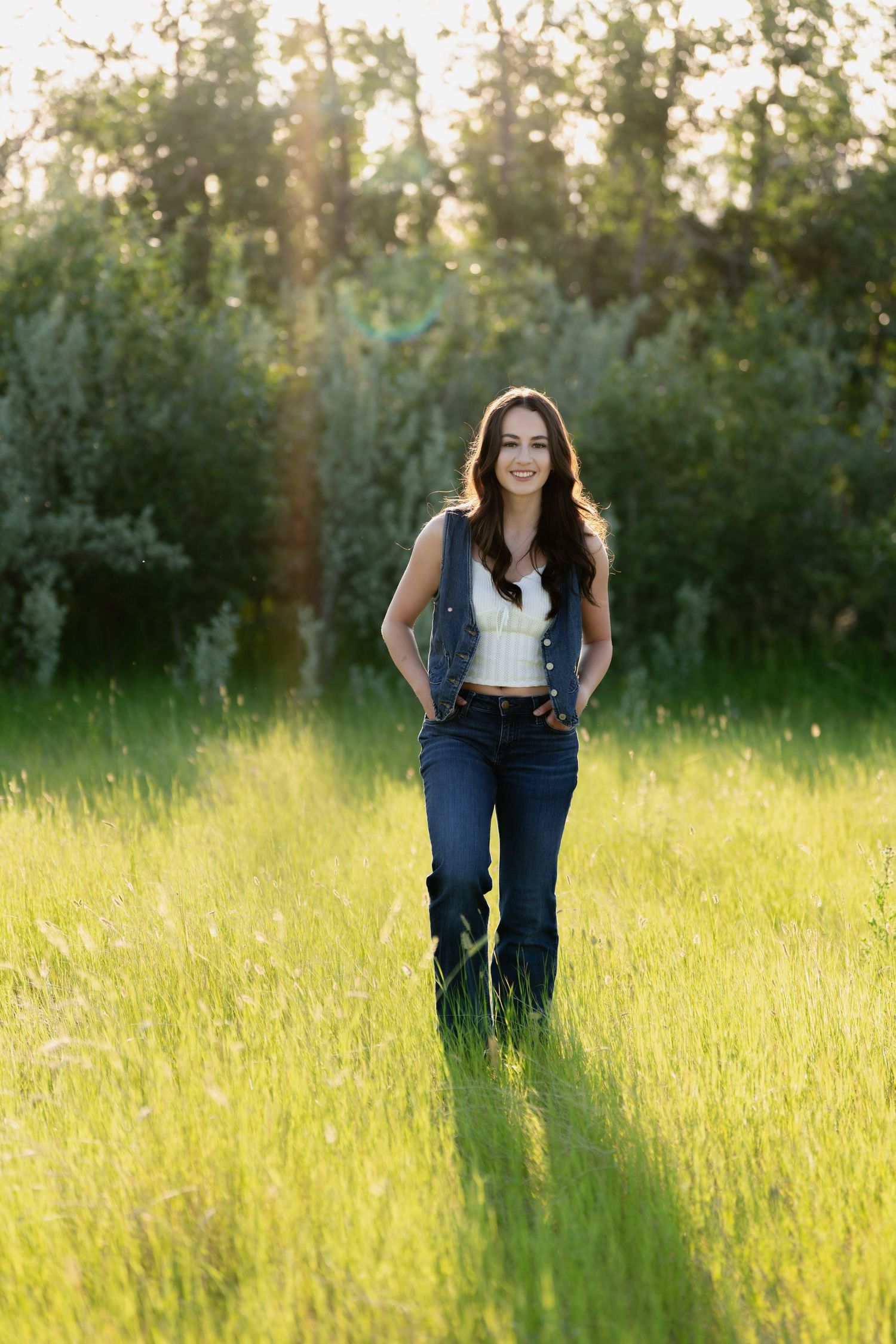 Casual outdoor portrait in sun-drenched field with natural backlight.