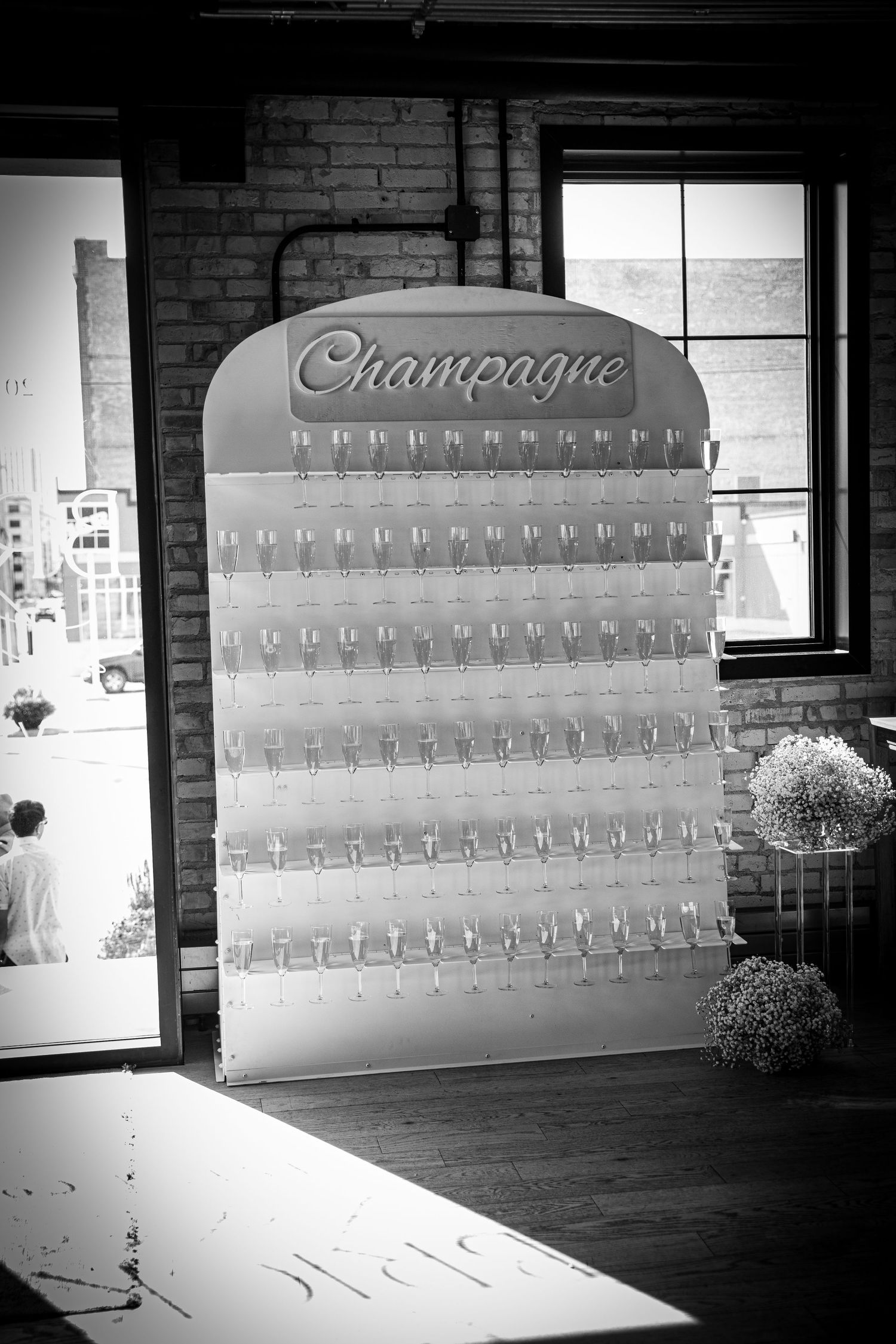 Wedding seating chart display with champagne theme in industrial brick venue.