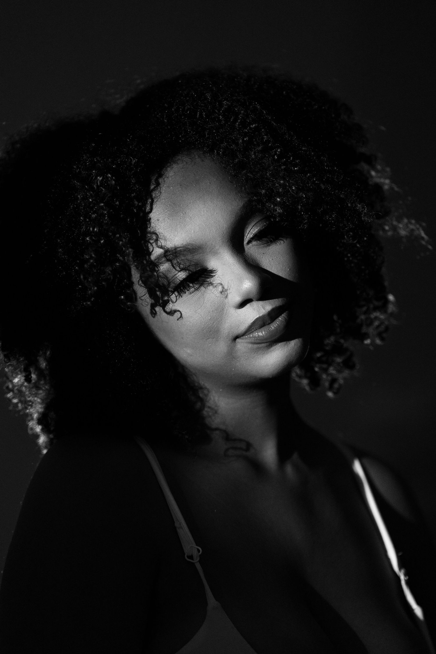 Dramatic black and white portraits featuring curly hair and moody lighting.