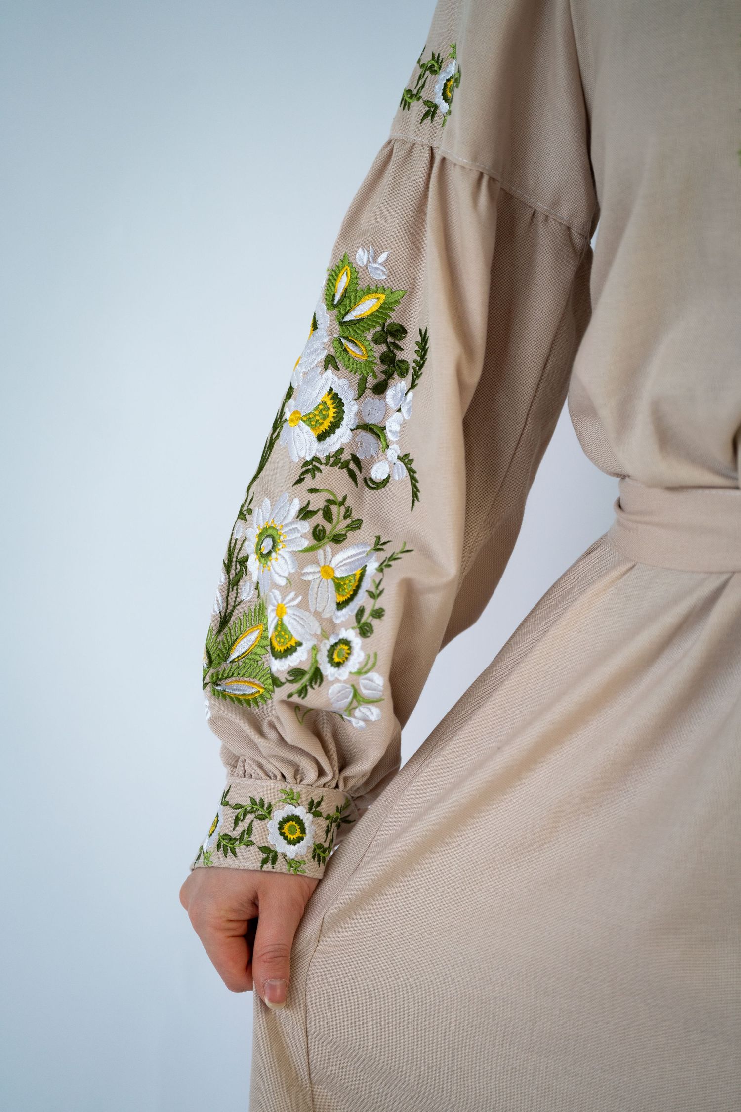 Traditional embroidered beige dress with floral sleeve detailing shown from different angles.