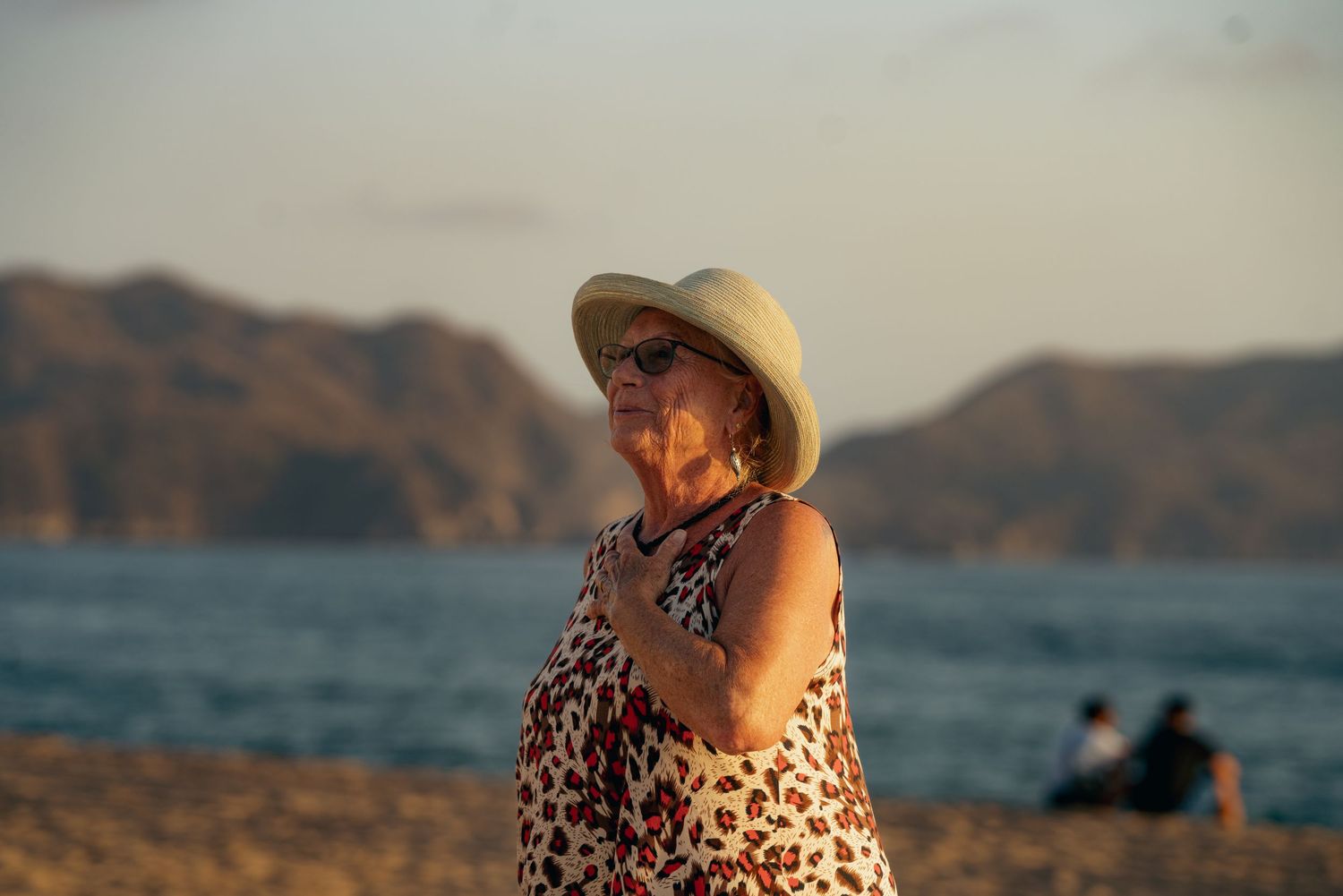 Sunset view of a coastline with mountains in the background.