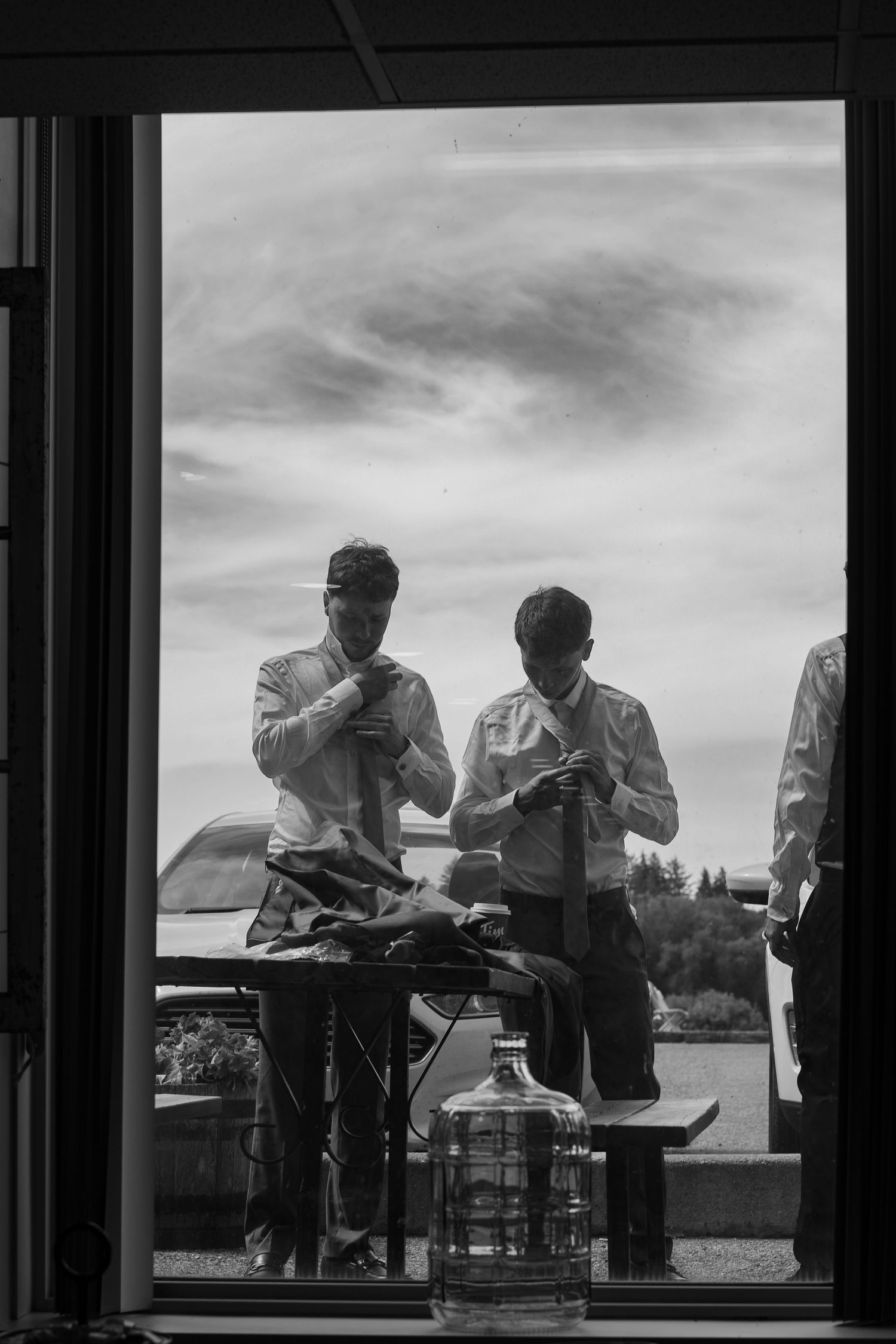 Silhouettes of people dining by a window with a scenic outdoor view.