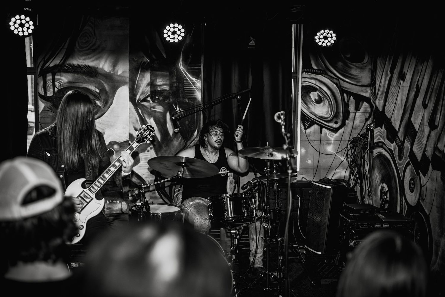 Dynamic concert photography showing musician playing guitar in dramatic lighting.