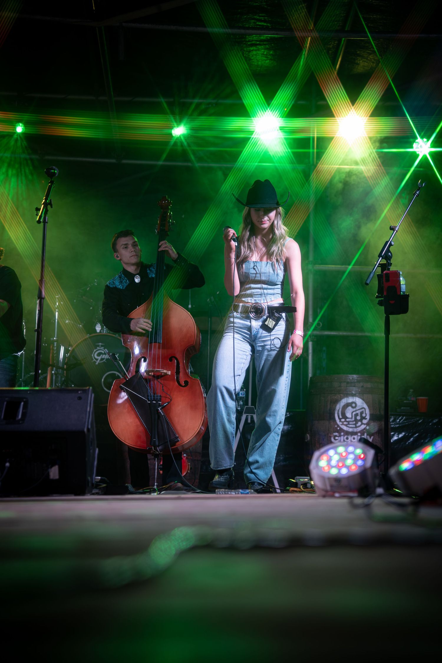 Band performing on stage with green lighting effects creating atmospheric ambiance.