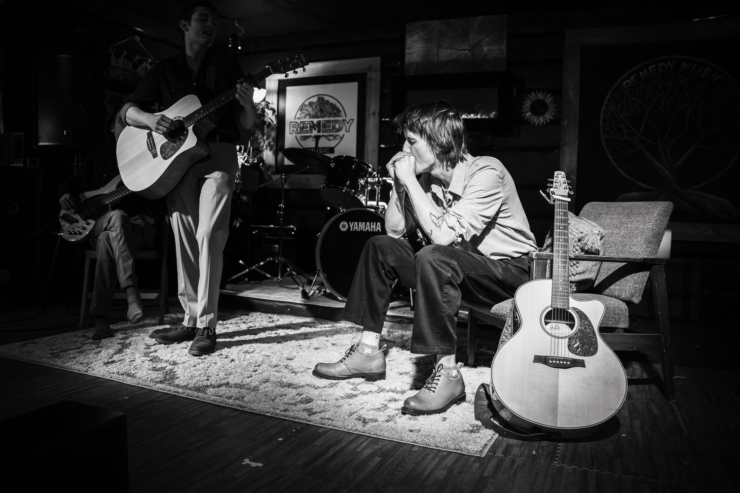 Musicians performing with guitars in a dimly lit venue creating an intimate atmosphere.