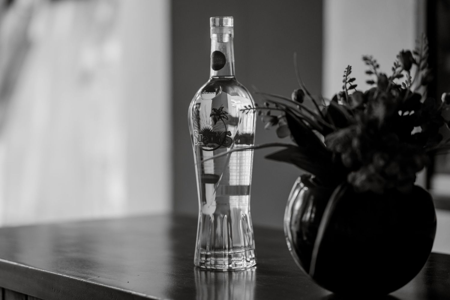 Glass bottles and decorative items casting shadows in natural window light.