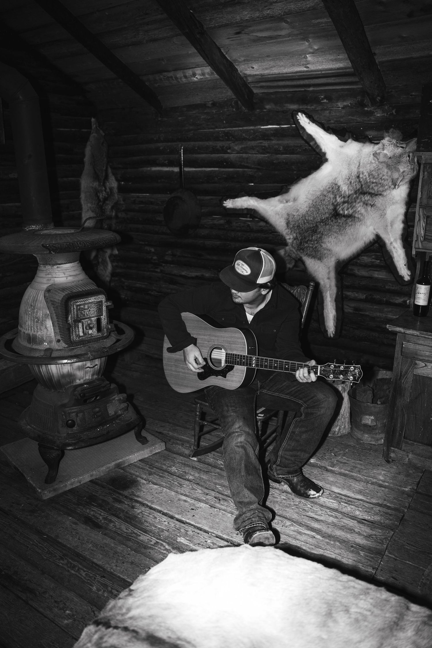 Musicians performing in a rustic log cabin with dramatic lighting.