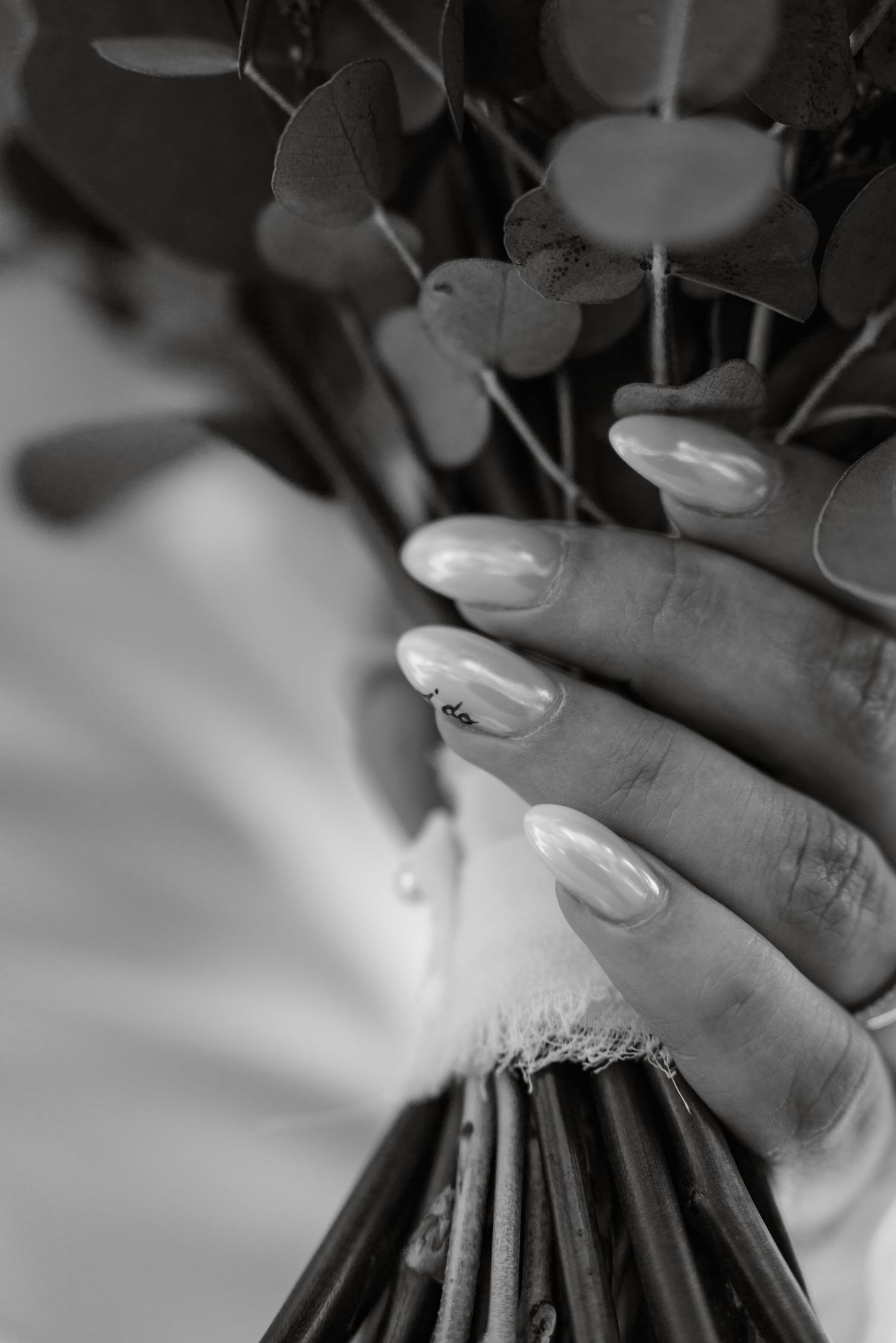 Close-up of elegant pearl white manicured nails against a soft blurred background.