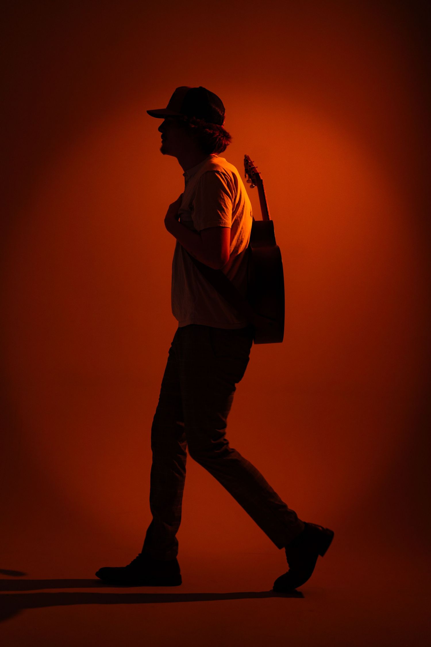 Silhouetted figure dances against warm orange backdrop in sequential motion.