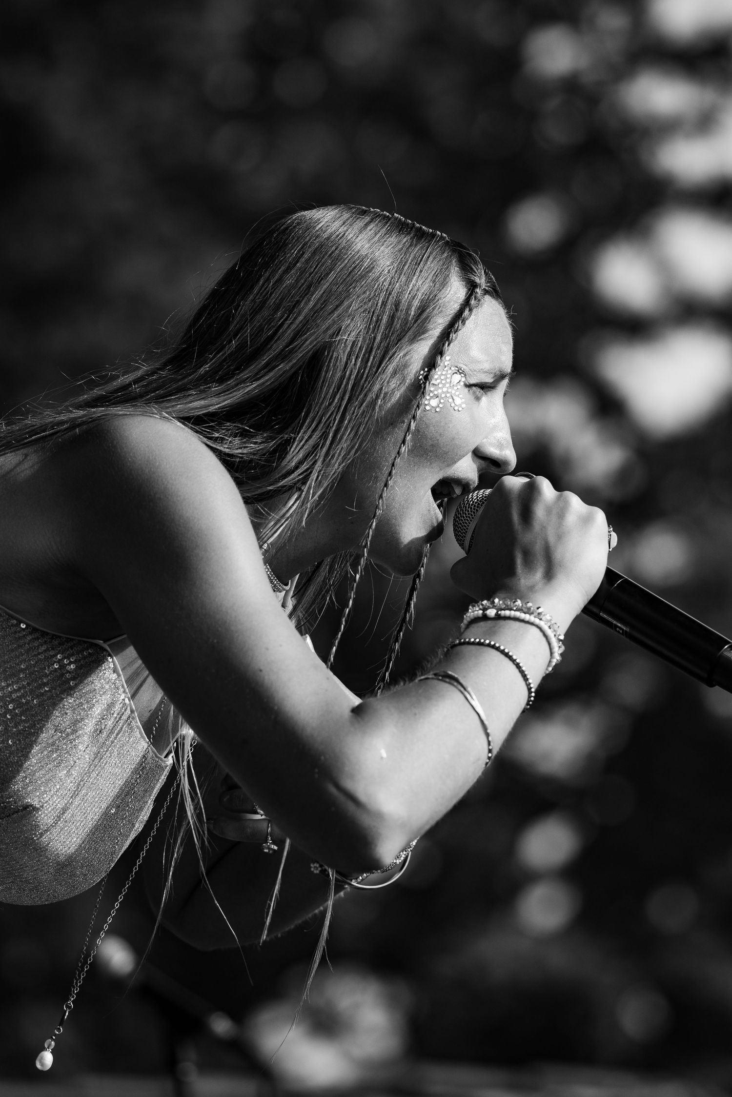 Black and white close-up profile of performer singing with intense emotion.