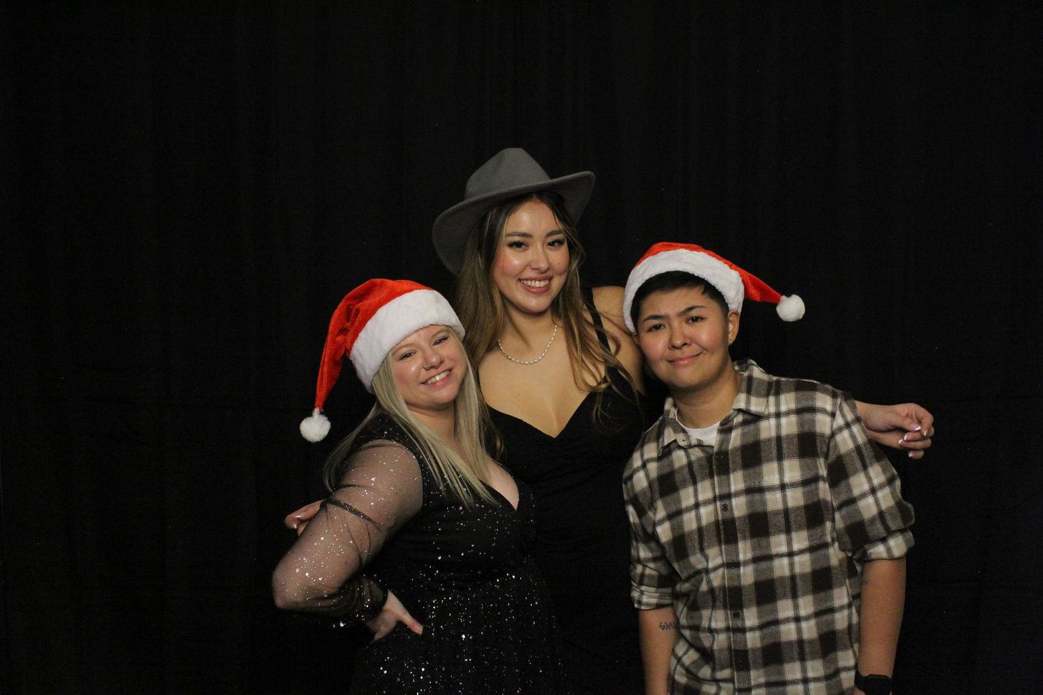 Group of guests posing for photos at a holiday party with wearable props
