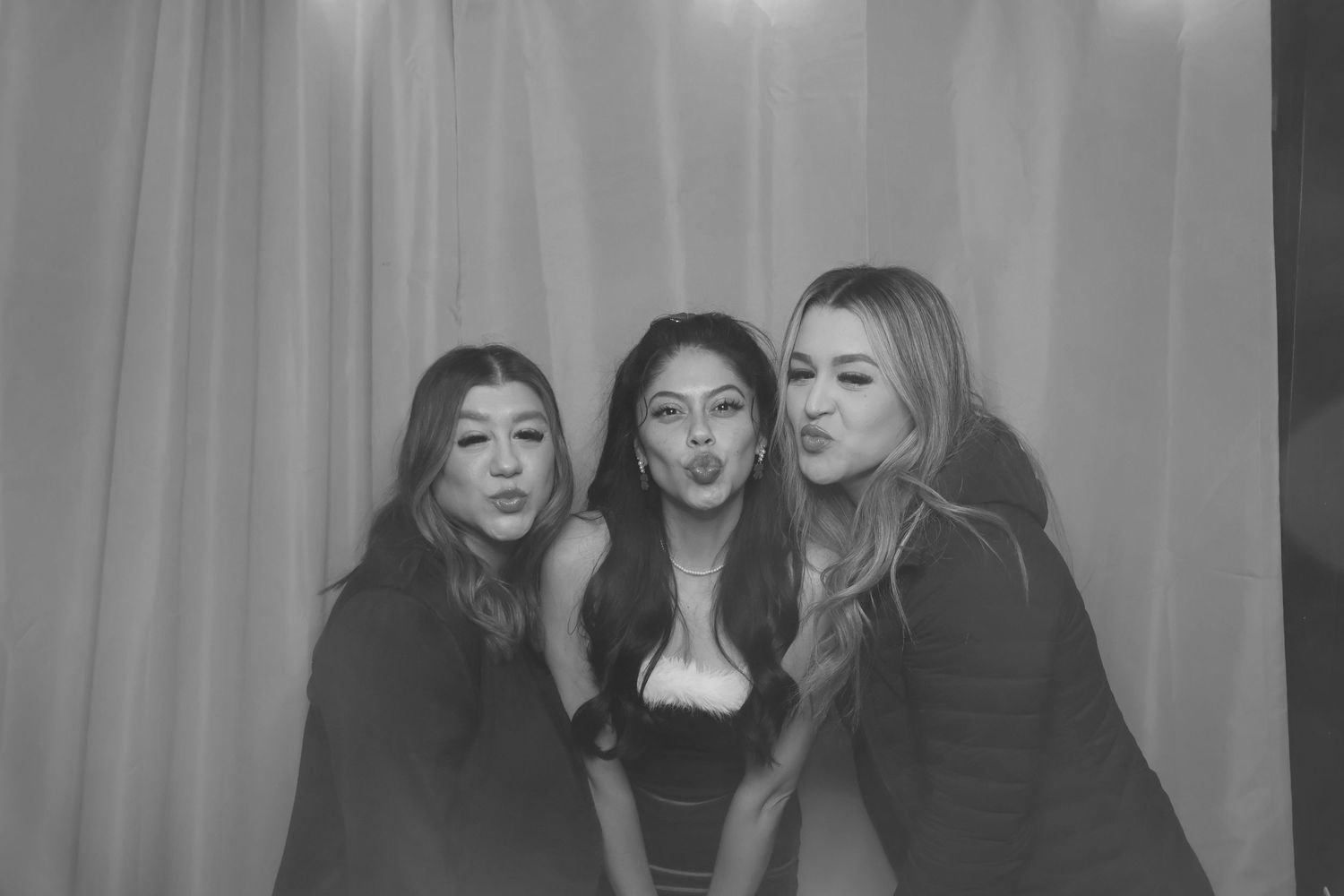 Friends posing together at a holiday celebration photo booth