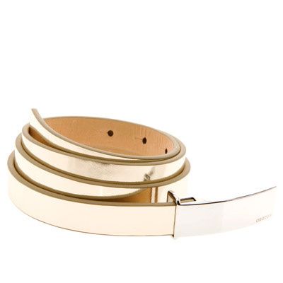 Cream patent leather slim belt with gold-tone buckle, coiled on white background.
