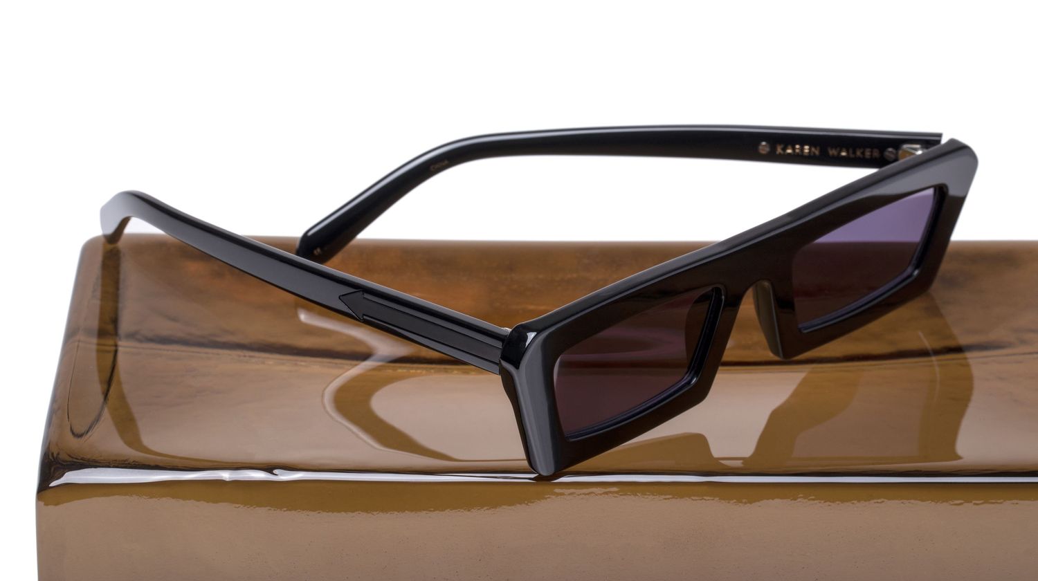 Sleek black rectangular cat-eye sunglasses resting on a brown box.
