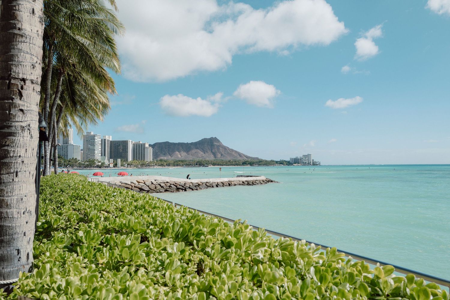 Waikiki Beach with Diamond Head crater, turquoise water, and palm trees in Hawaii.