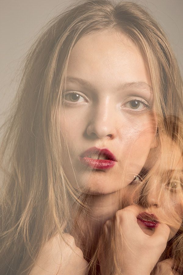 Double exposure portrait of young woman with red lips and blonde hair.