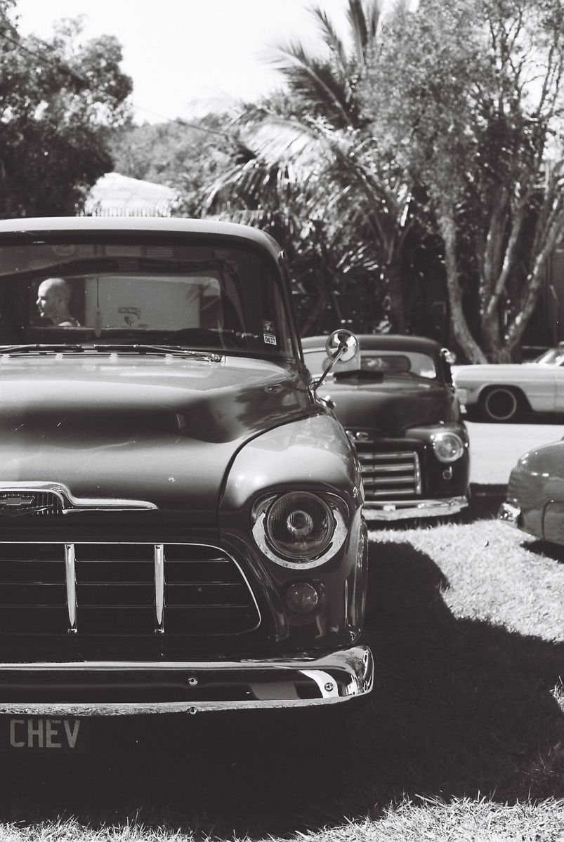 Vintage Chevrolet truck parked in black and white at a classic car show.