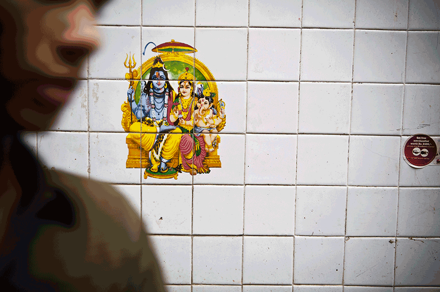A colorful Hindu deity tile artwork of Lord Shiva and Parvati mounted on white ceramic wall tiles.