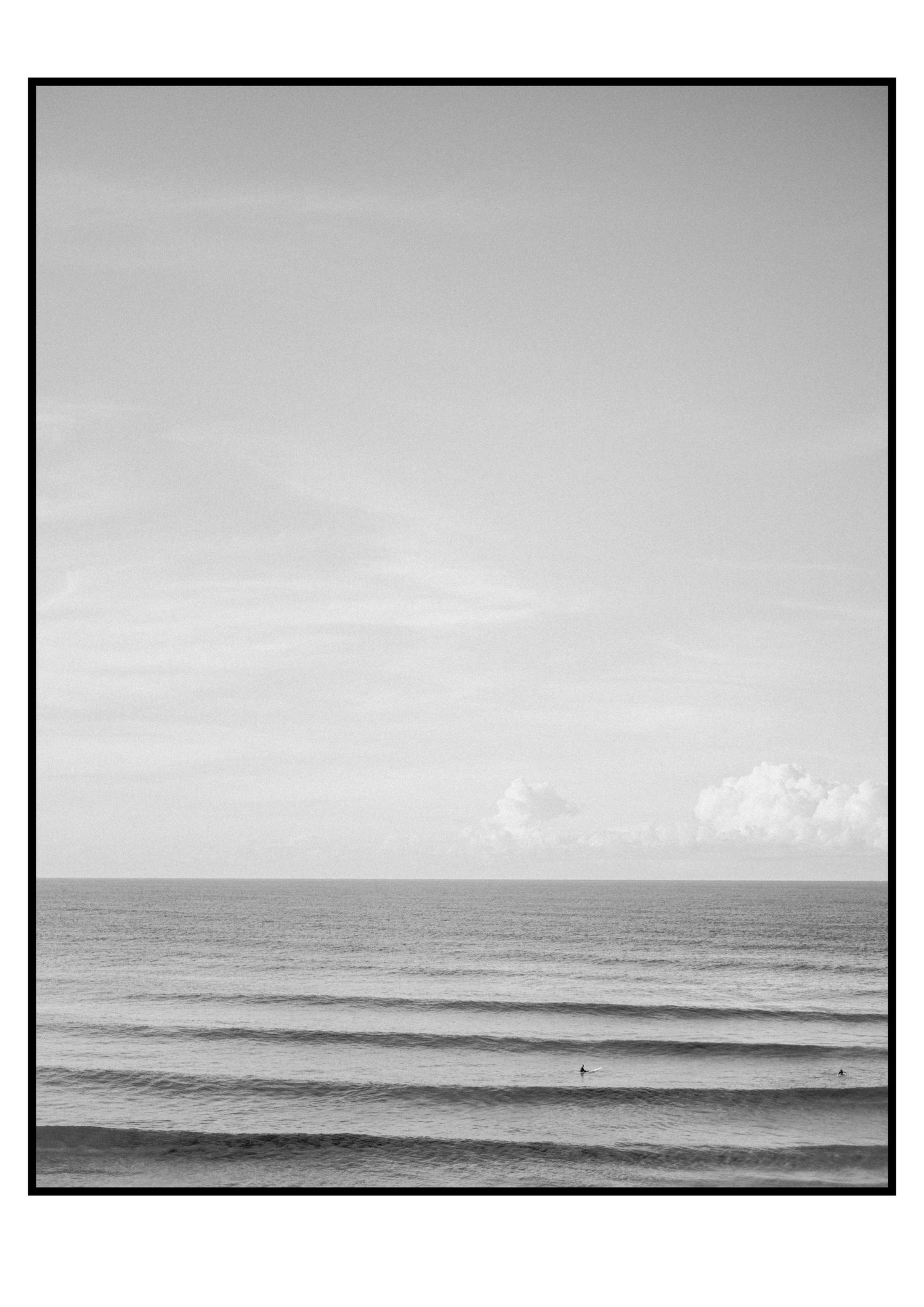 Black and white minimalist seascape with rolling waves, vast ocean, and dramatic cloudy sky.
