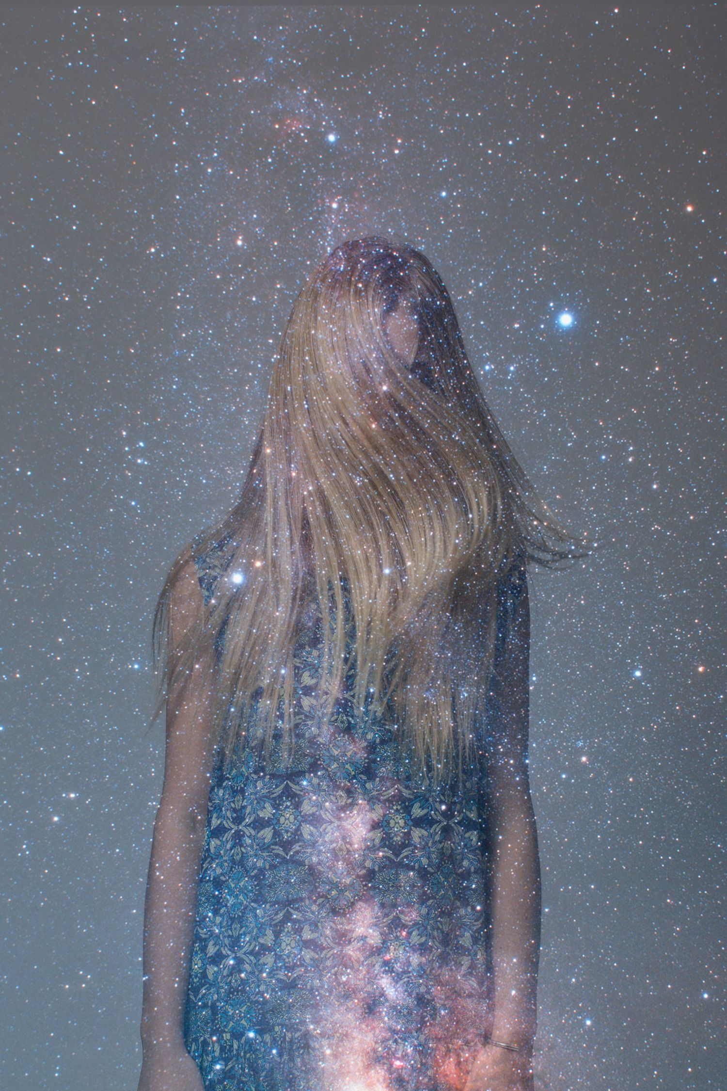Artistic double exposure of a blonde woman blending with a stunning starry night sky galaxy background.