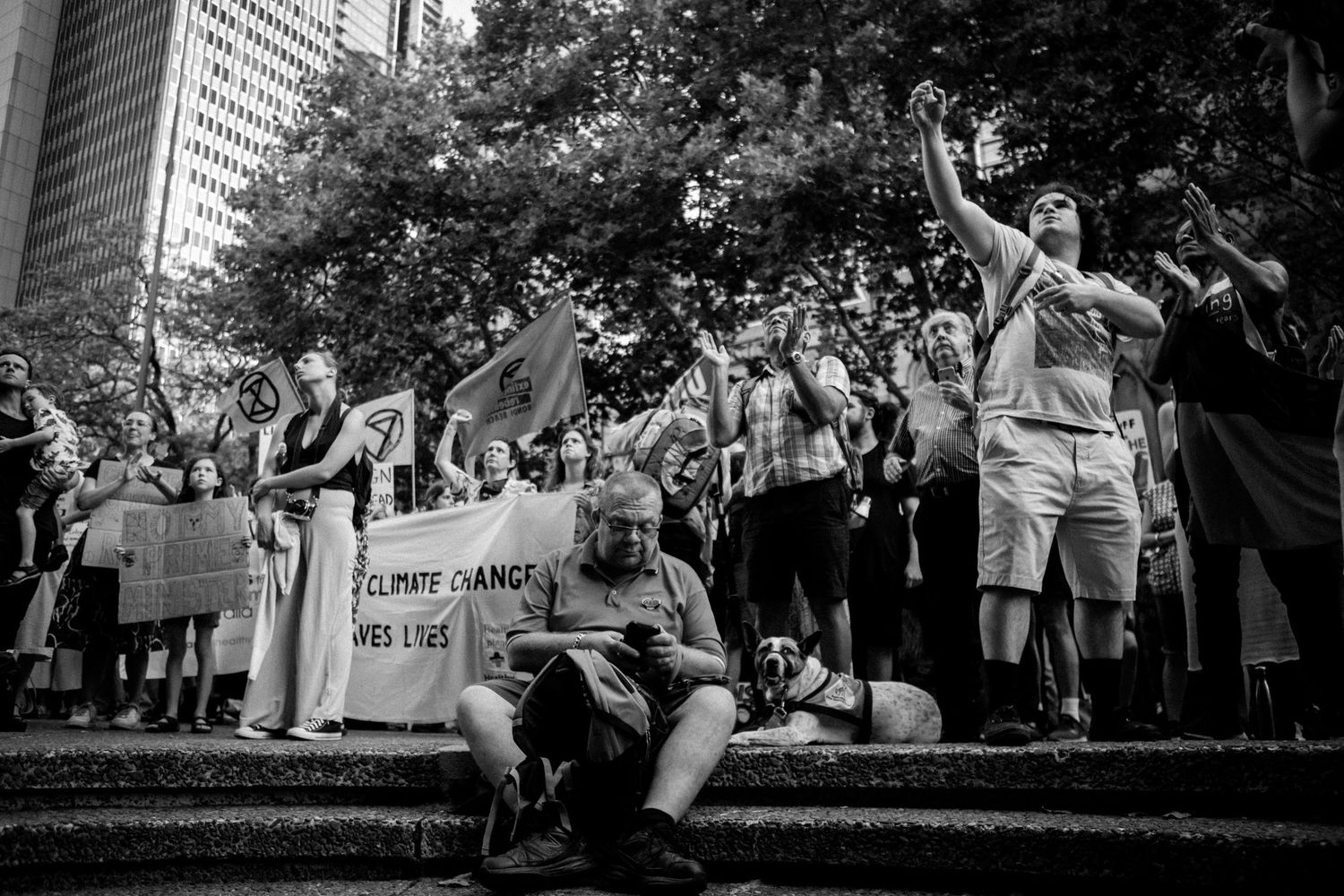 Black and white photo of a climate change protest rally with crowd holding signs.
