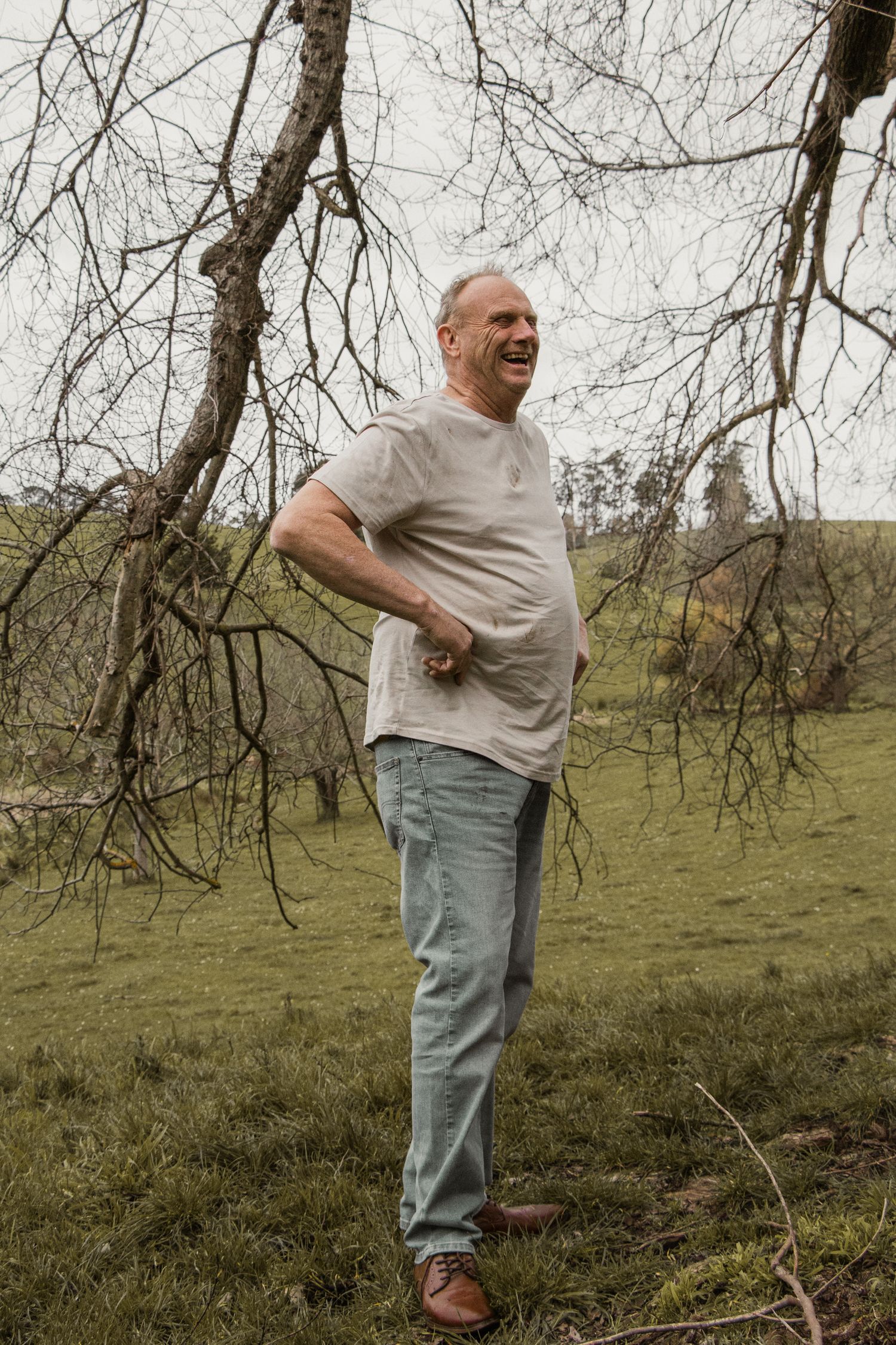 Grandpa standing and laughing,  in the afternoon at lifestyle family photography session in Trafalgar, West Gippsland.