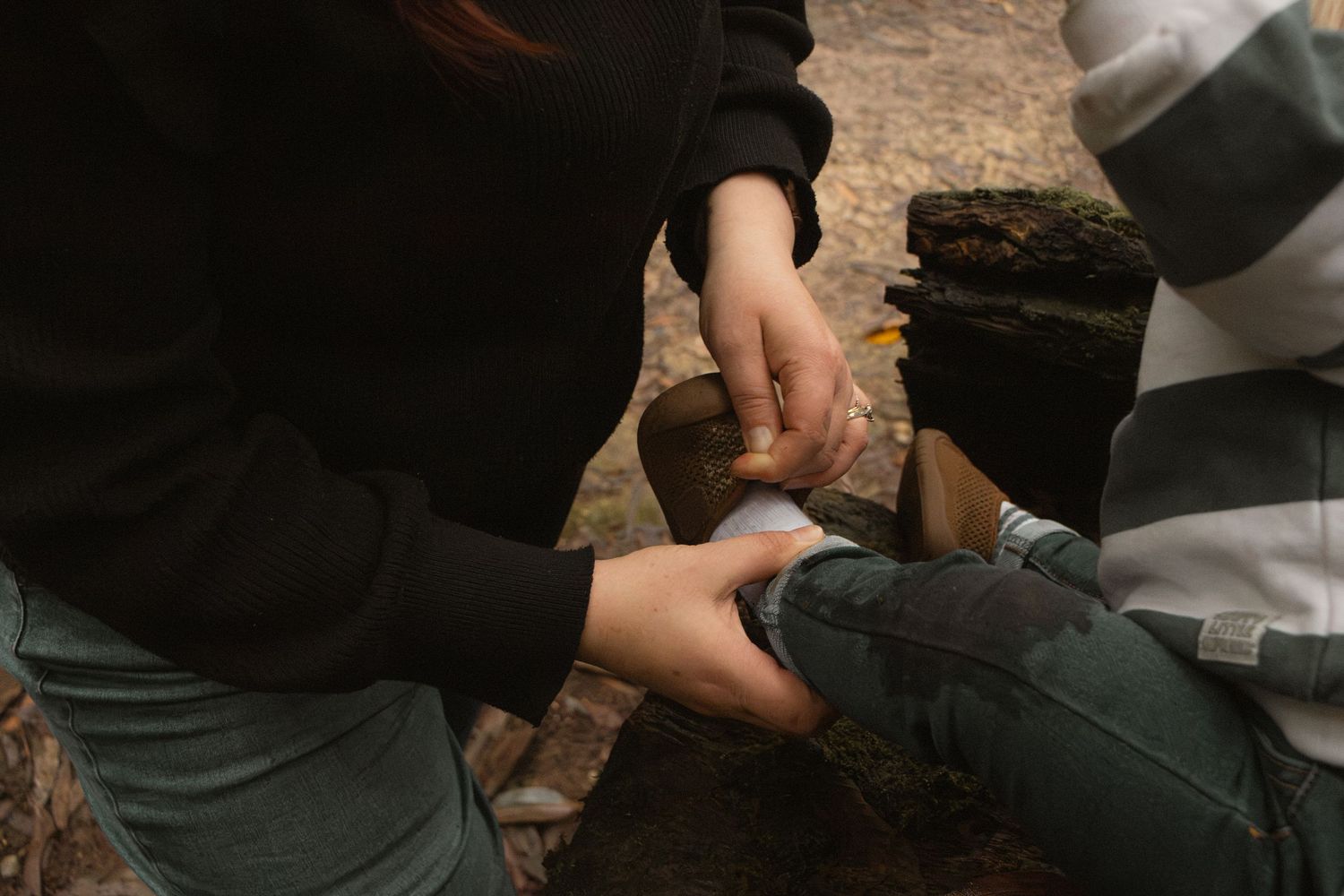 Mother putting on sons shoe, in the morning at lifestyle/documentary motherhood photo session in the outdoors in Trafalgar, West Gippsland.