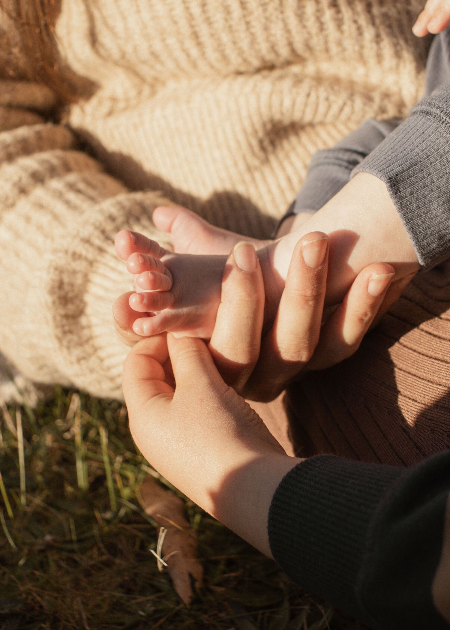 A family playing with babies feet at blue rock lake in the outdoors in central Gippsland. Taken for a motherhood/pet session.